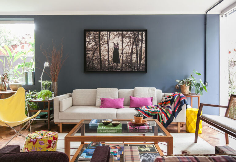 Sala com parede escura e móveis coloridos