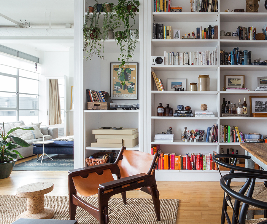 Apartamento com estante embutida, plantas e móveis vintage