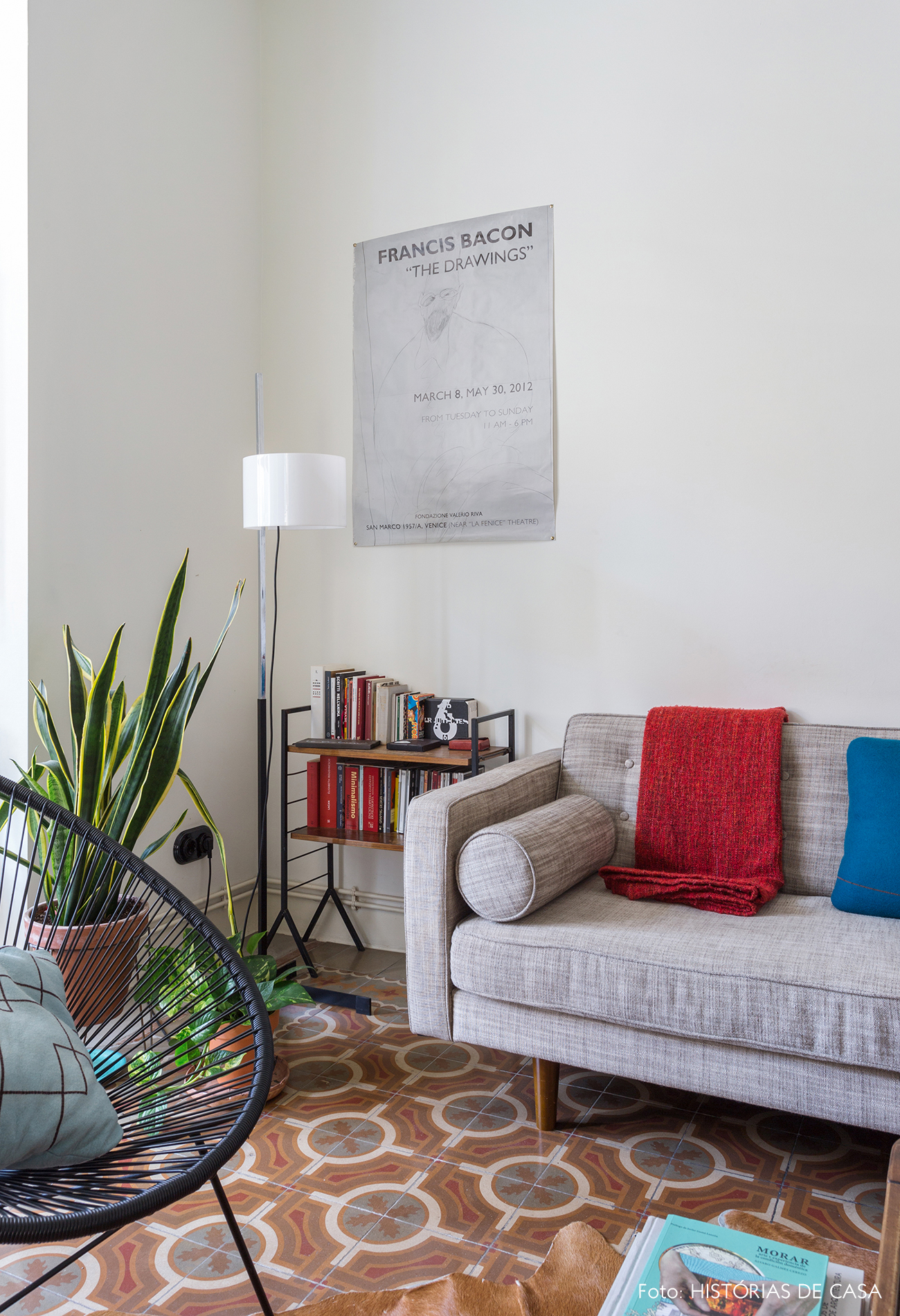 Sala com sofá cinza e piso de ladrilhos hidráulicos