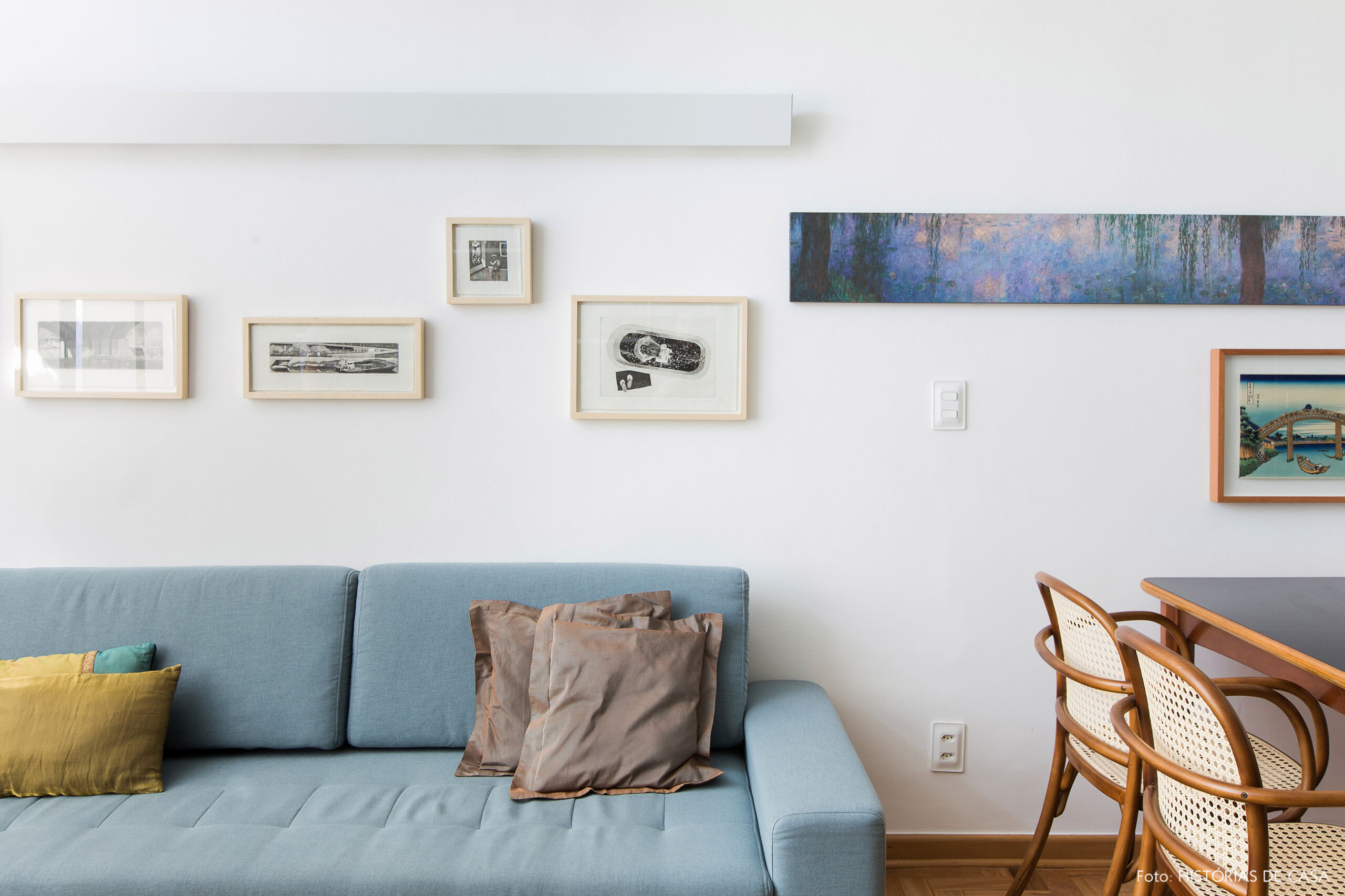 Sofá azul claro com quadros na parede