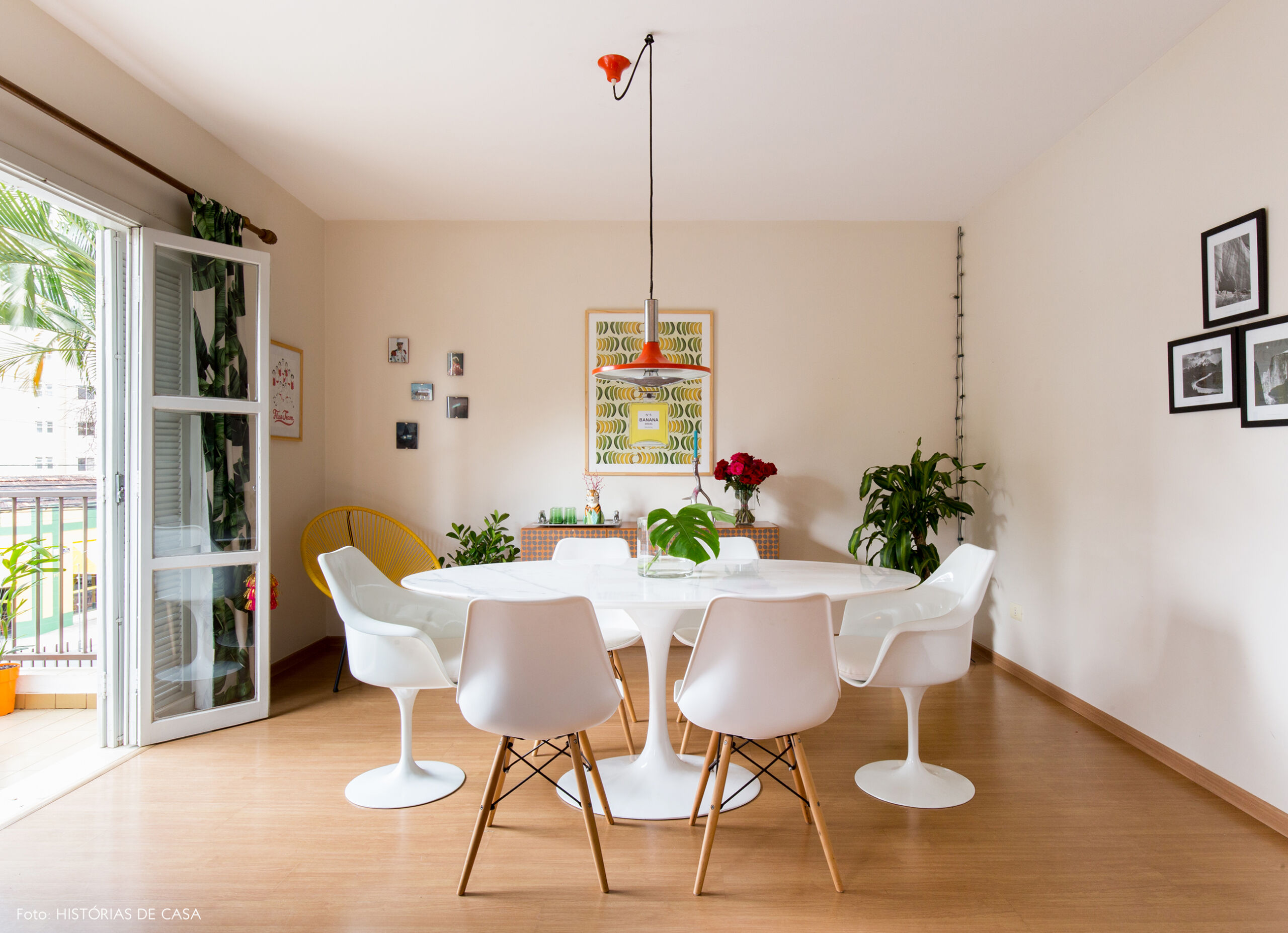 Sala de jantar com mesa Saarinen branca e pendente vintage