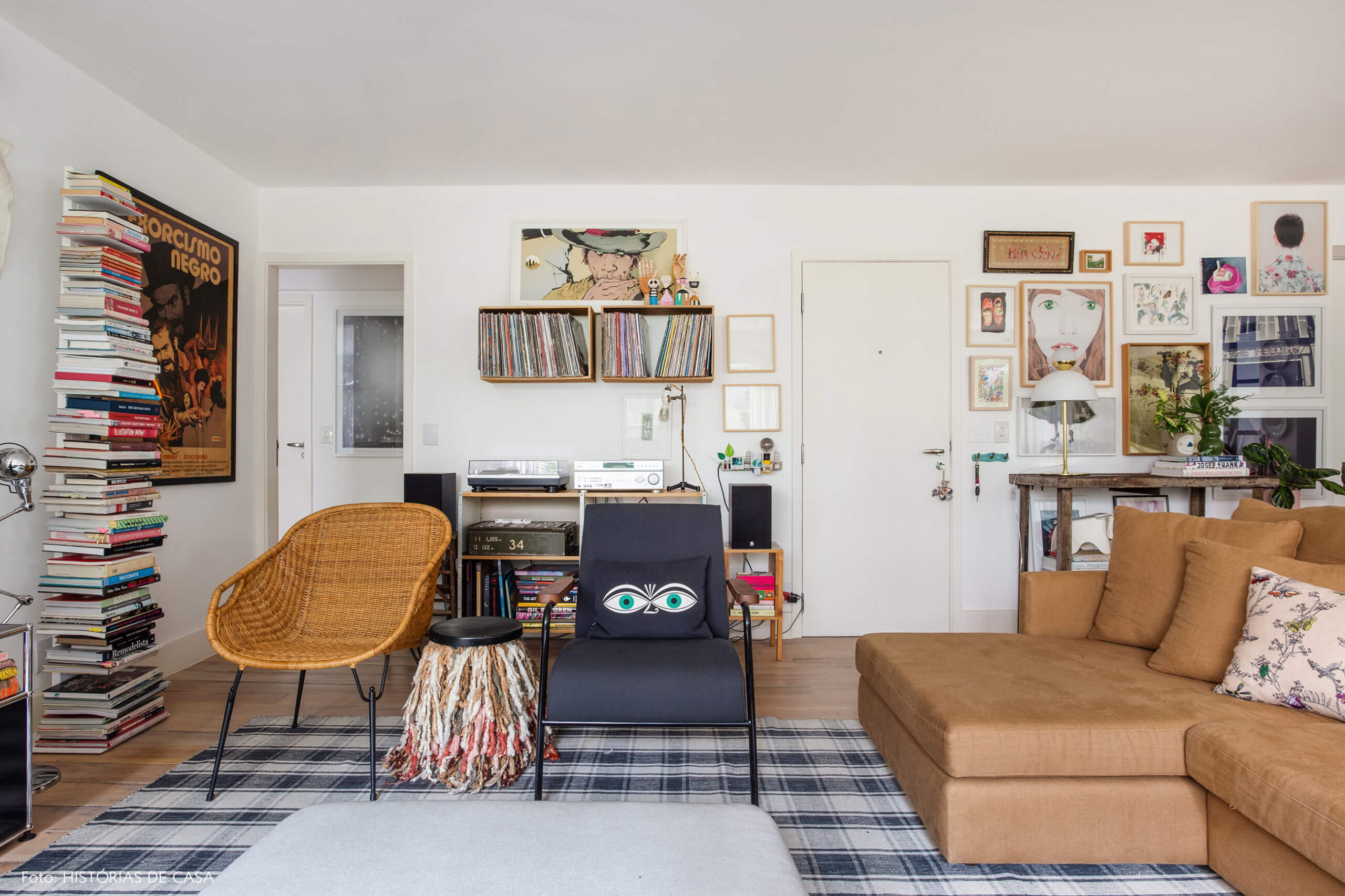 Sala com poltrona de vime e tapete preto e branco