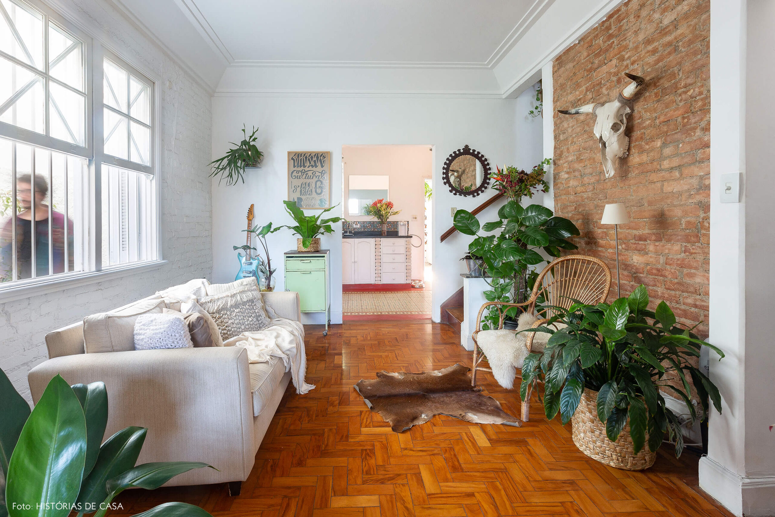 Casa de vila com salas integradas e paredes de tijolinho