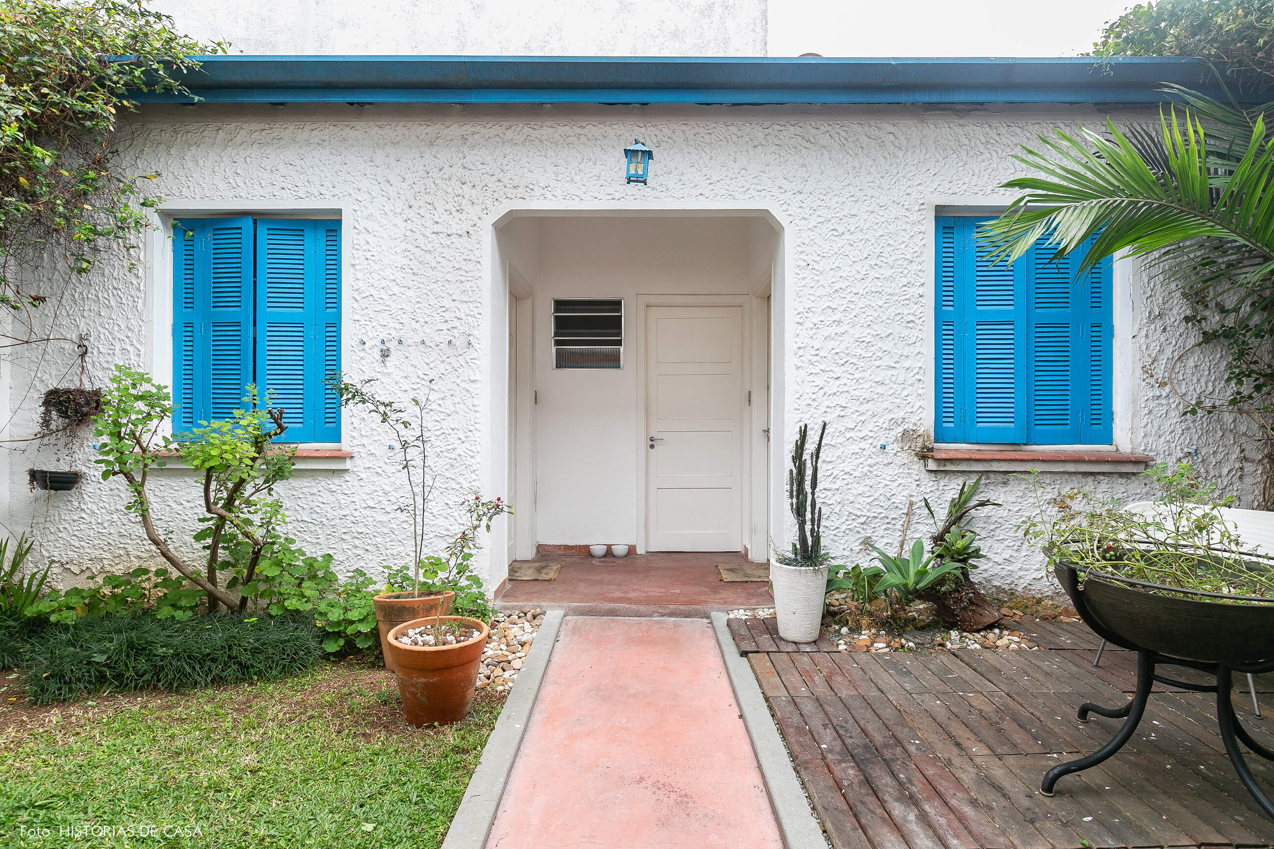 Quintal de casa com janelas pintadas de azul