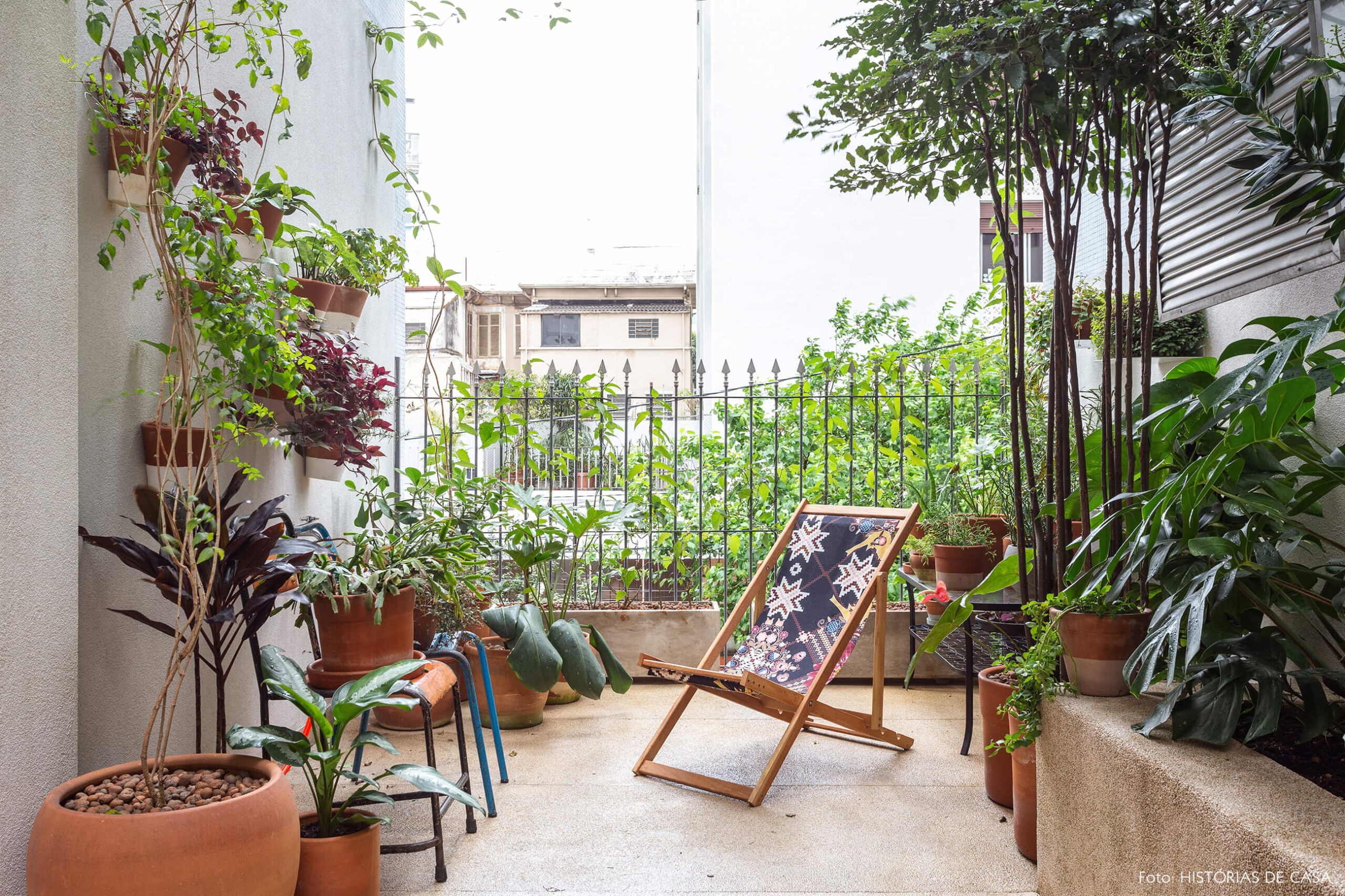 Jardim com muitas plantas e espreguiçadeira