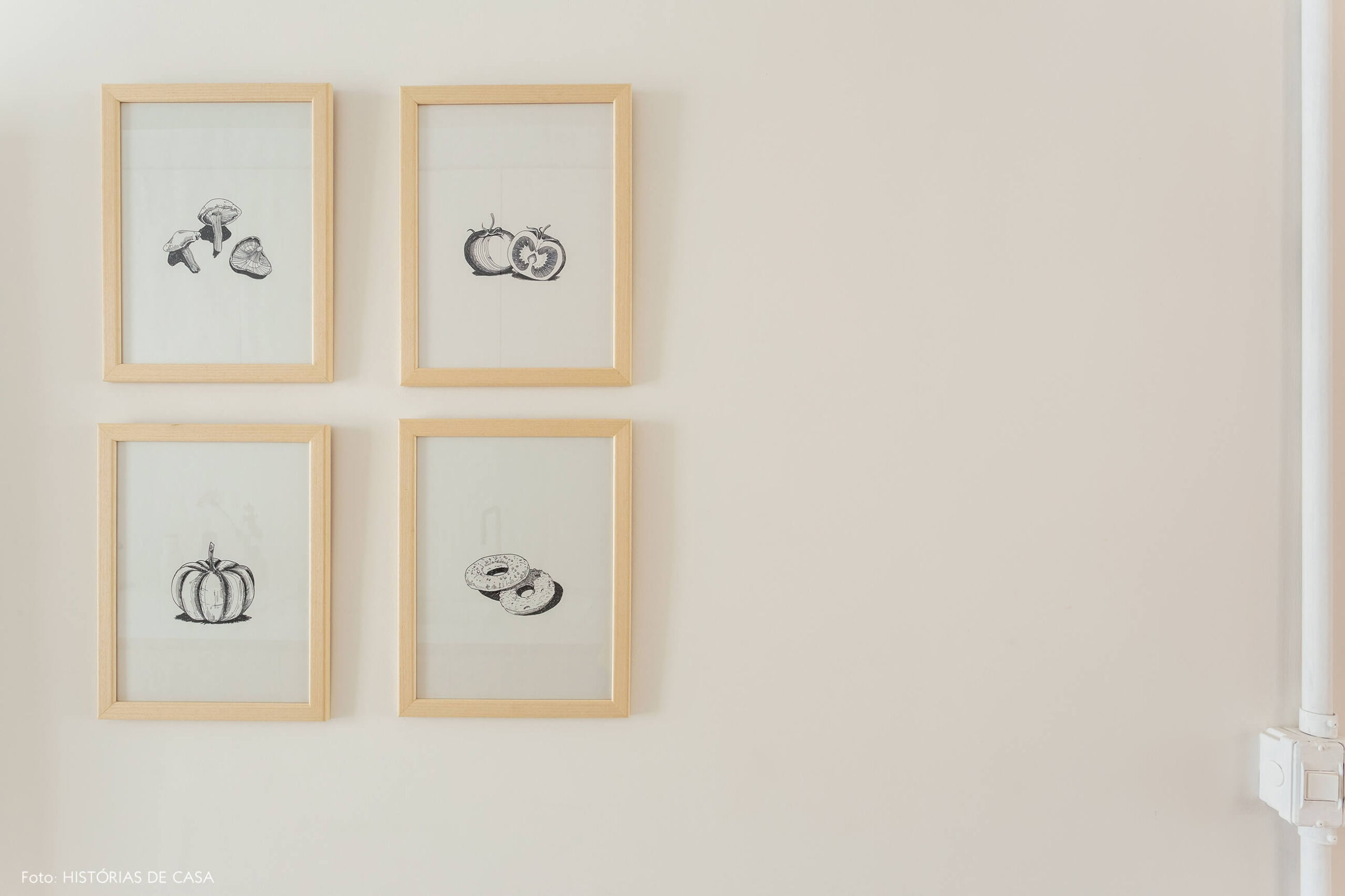 Gravuras em preto e branco na parede da cozinha