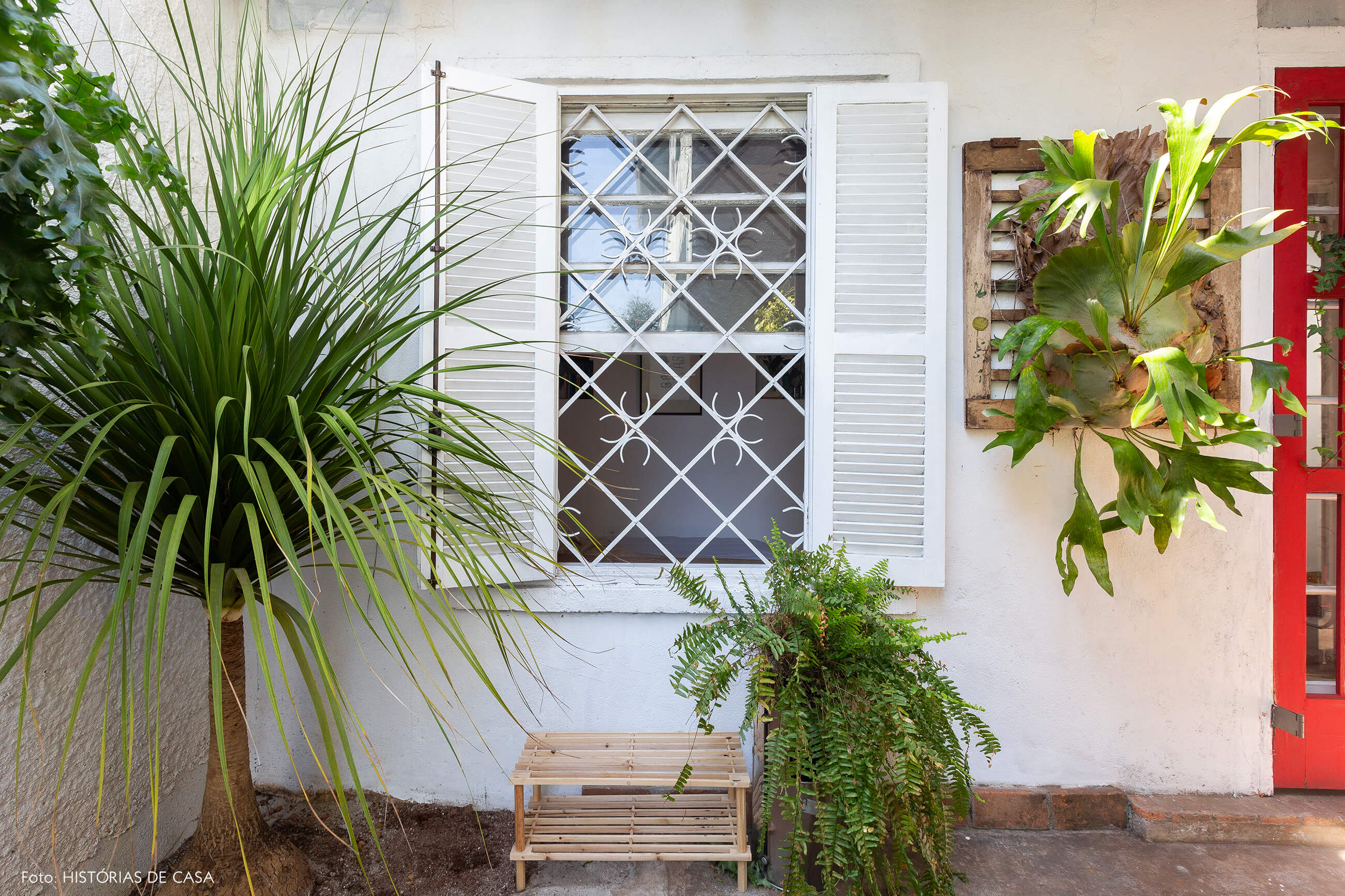 Casa de vila com janelas antigas e muitas plantas