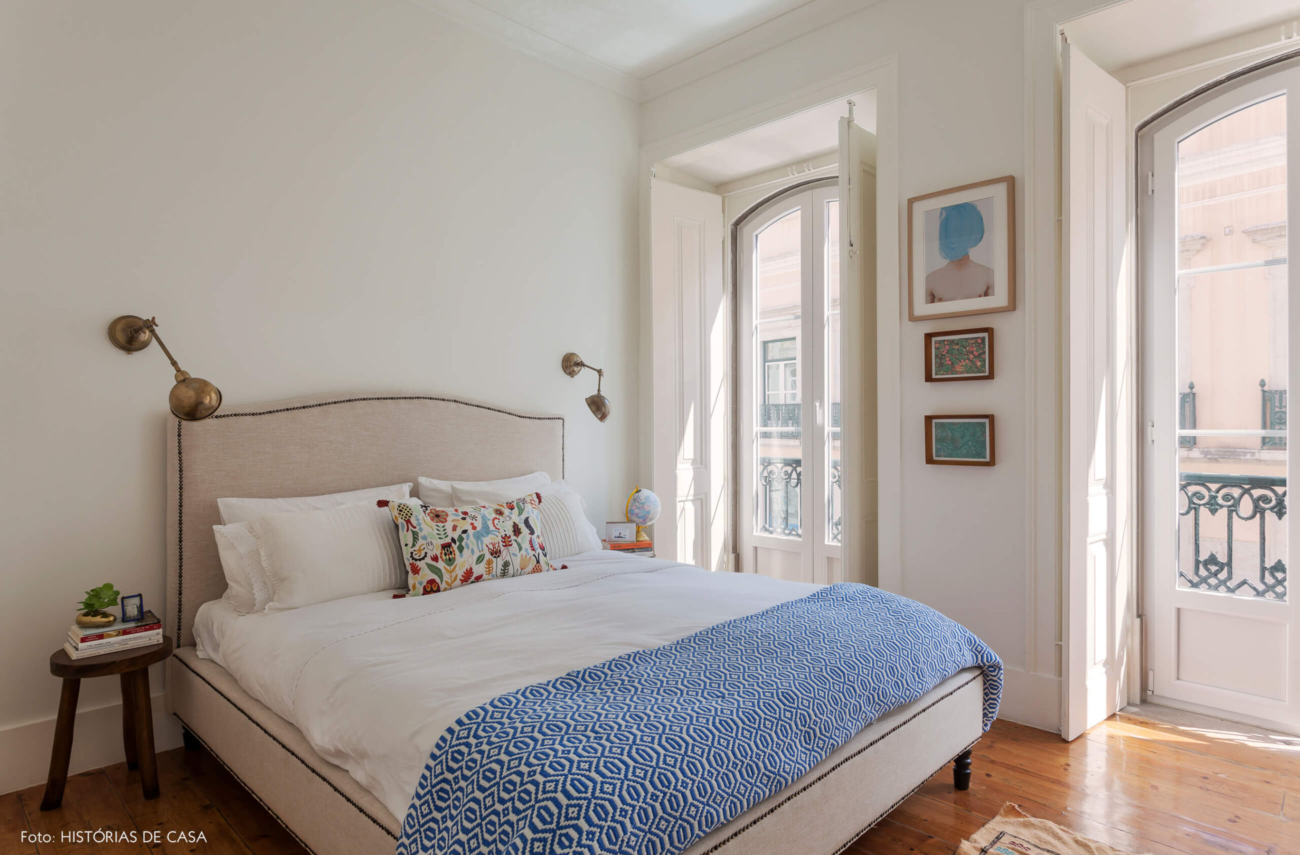 Quarto com cabeceira de tecido e arandelas