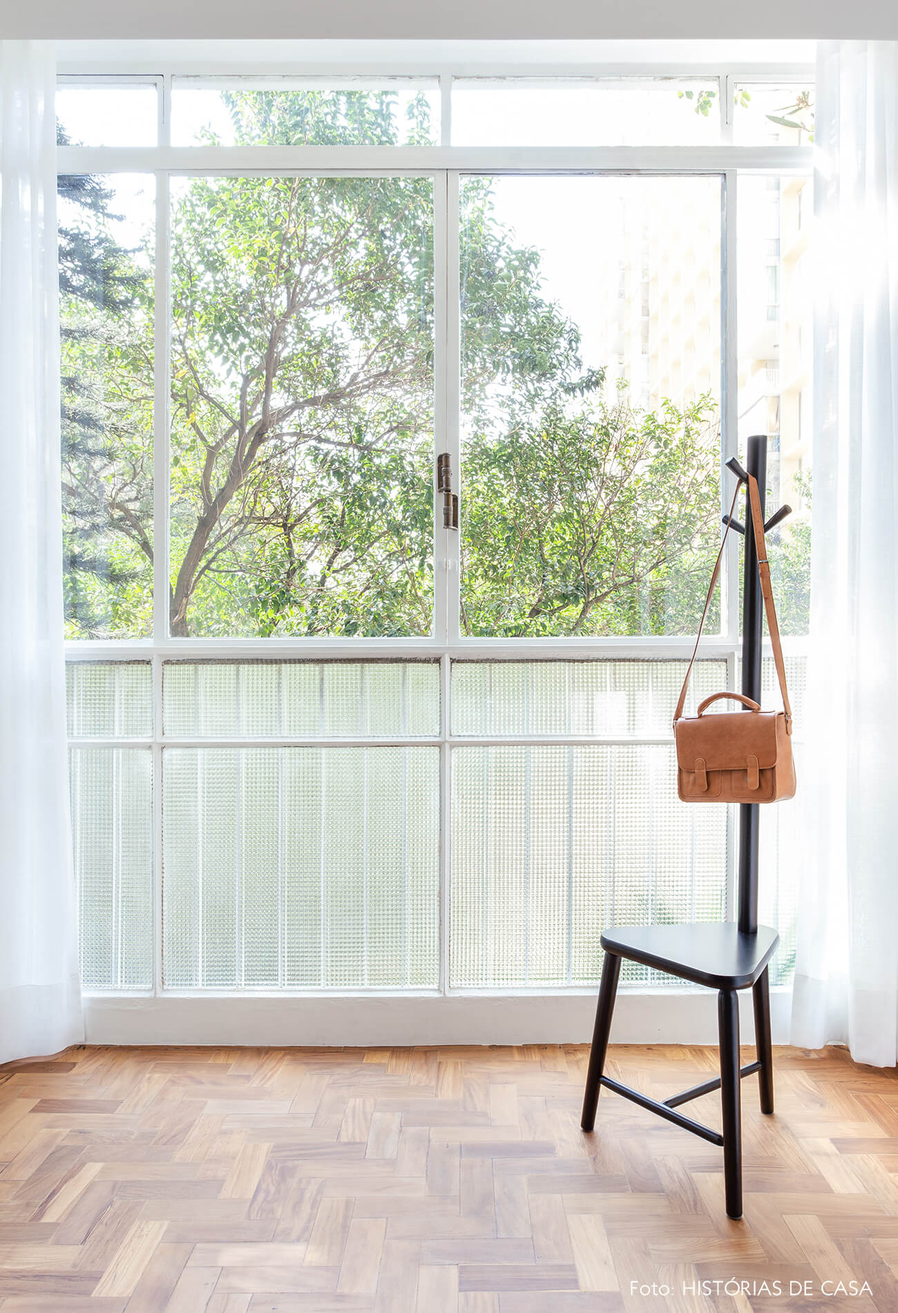 Janelas antigas com vista para as árvores e piso de taco