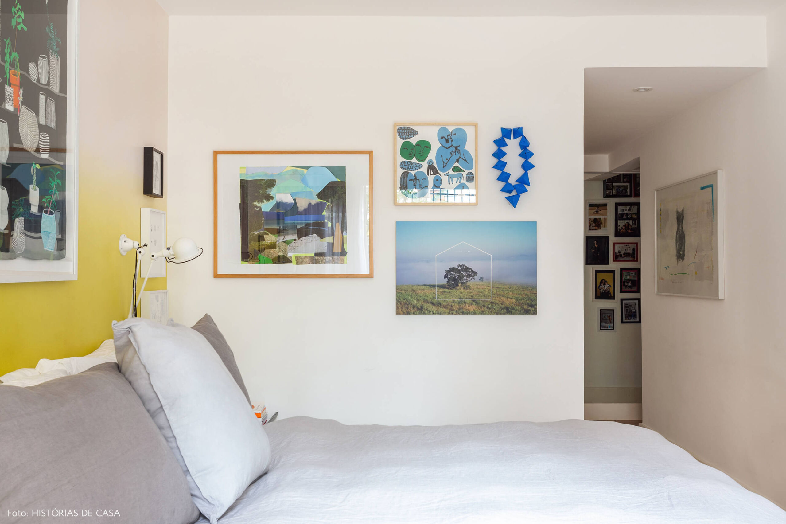 Quarto de casal com papel de parede e parede de quadros azuis