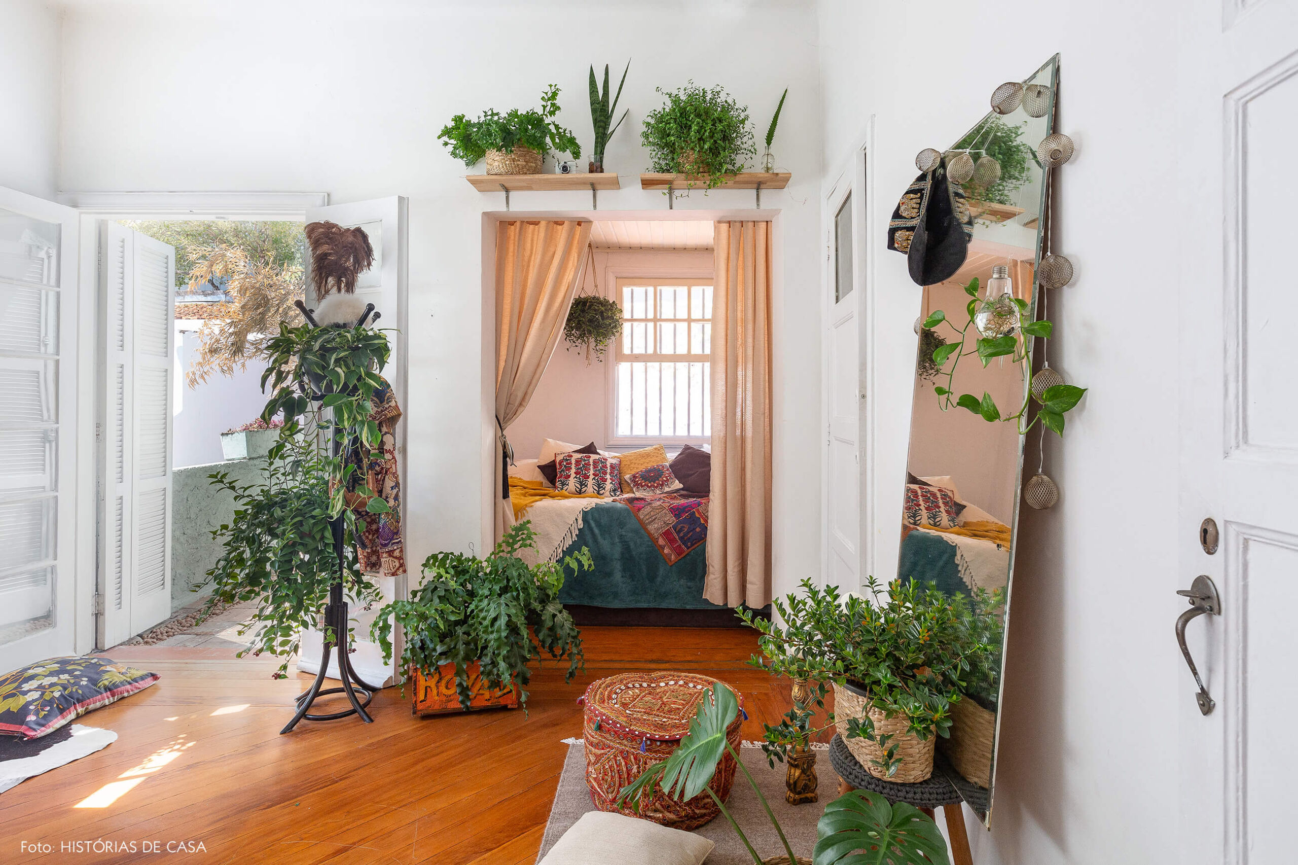 Quarto com tenda estilo étnica e muitas plantas