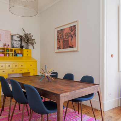 Sala de jantar com tapete rosa e móvel amarelo