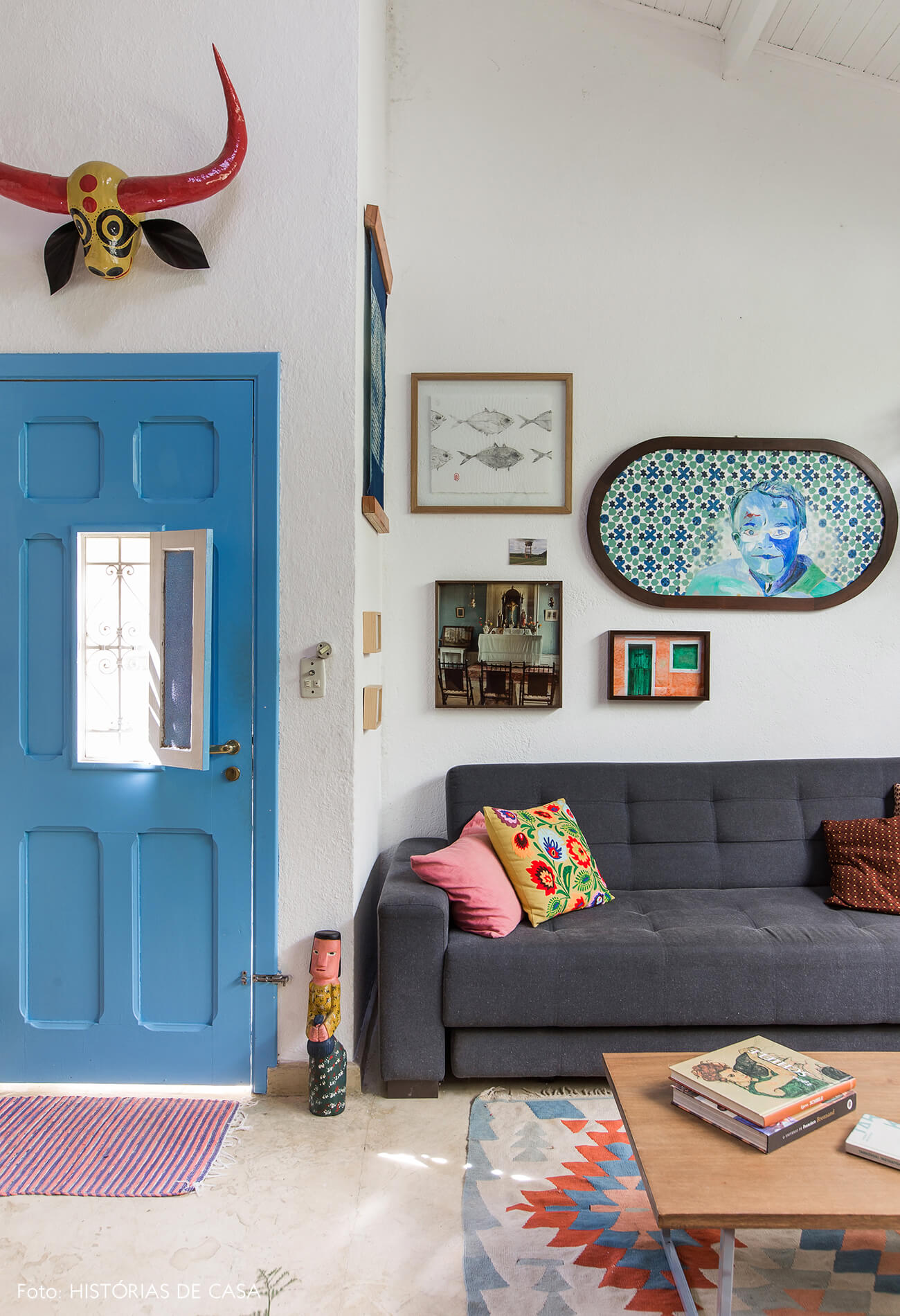 Sala bem colorida com porta azul e muitos quadros