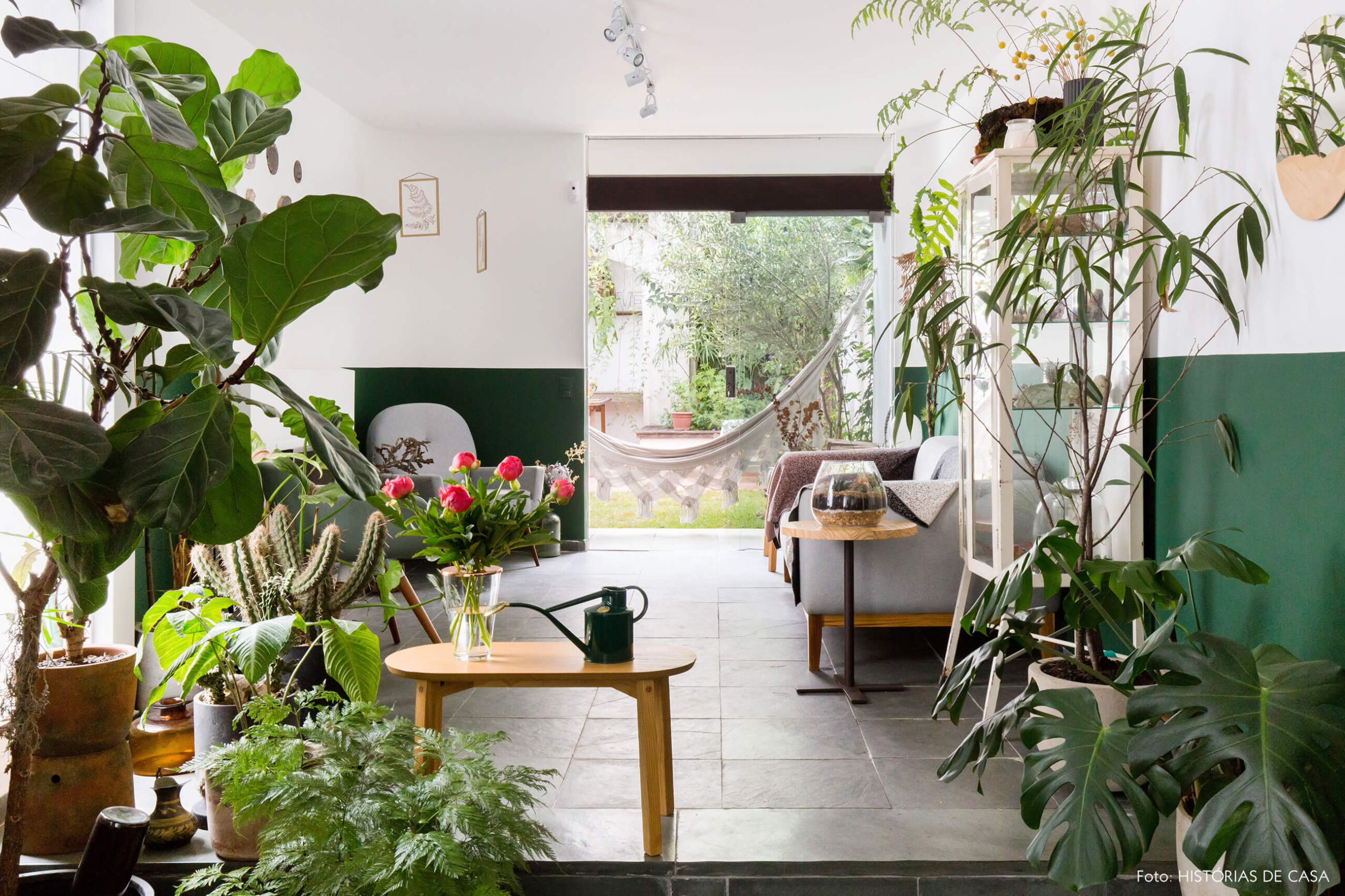 Sala com muitas plantas e piso cinza