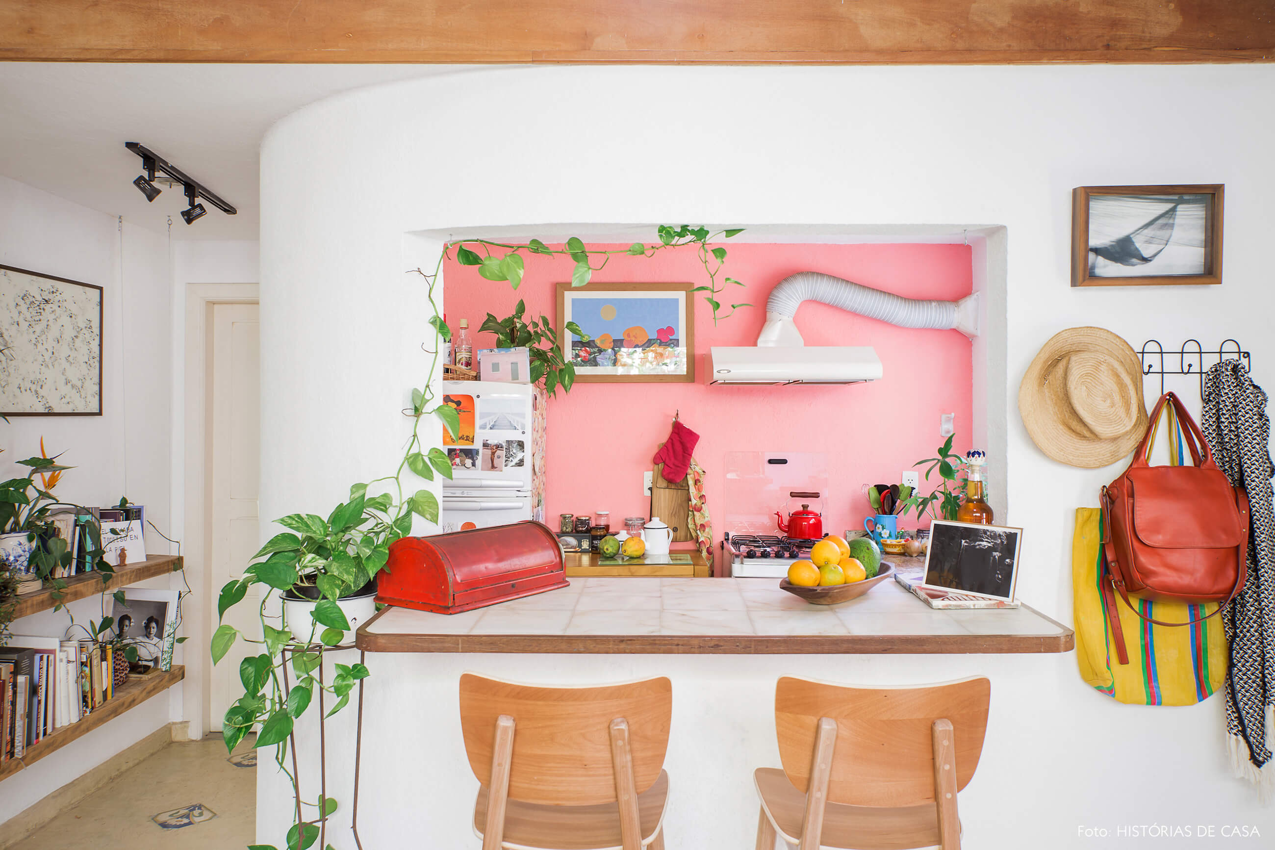 Cozinha americana com balcão e parede colorida