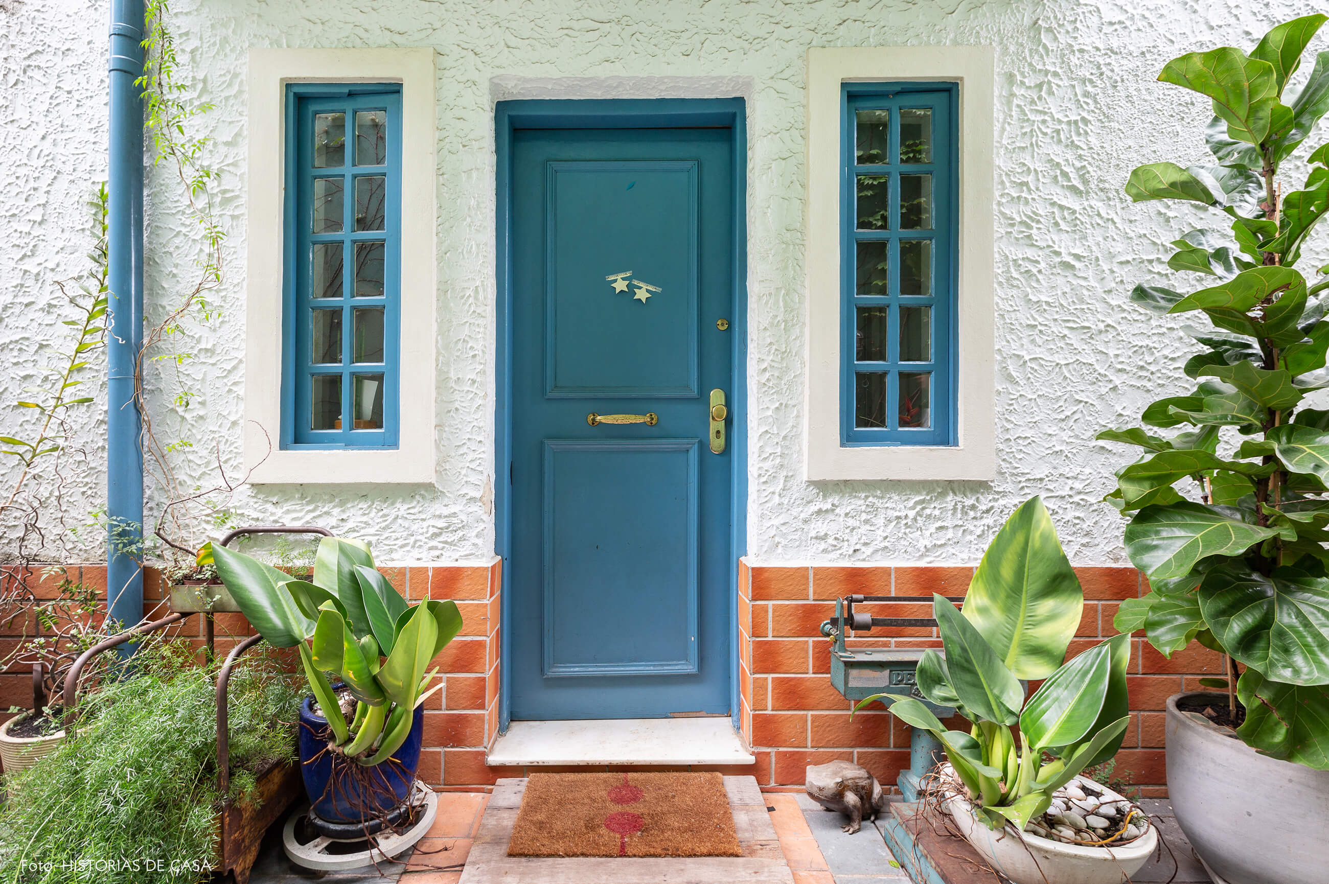 Casa com fachada charmosa e portas pintadas de azul