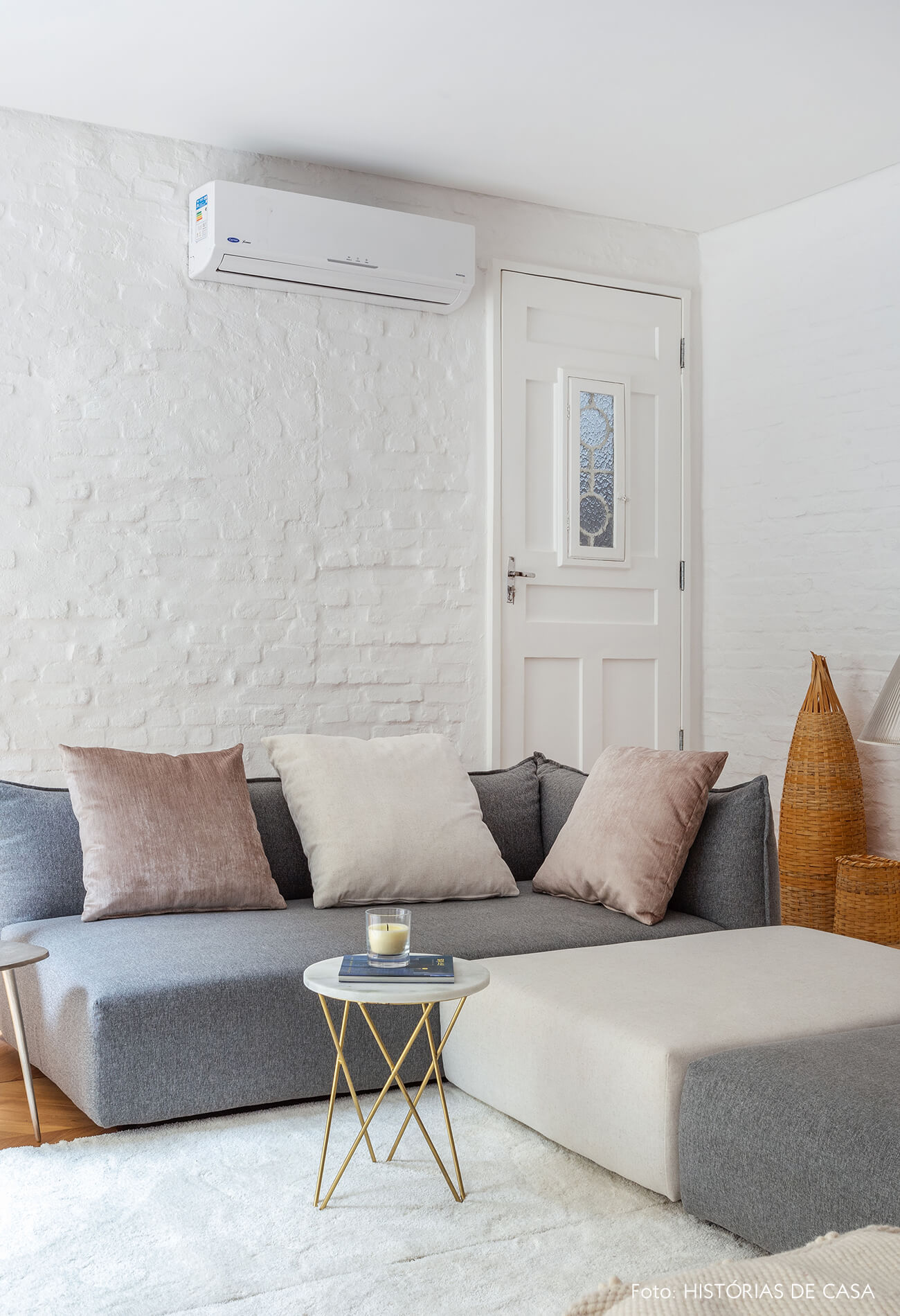 Sala integrada com tijolinho branco e sofá cinza