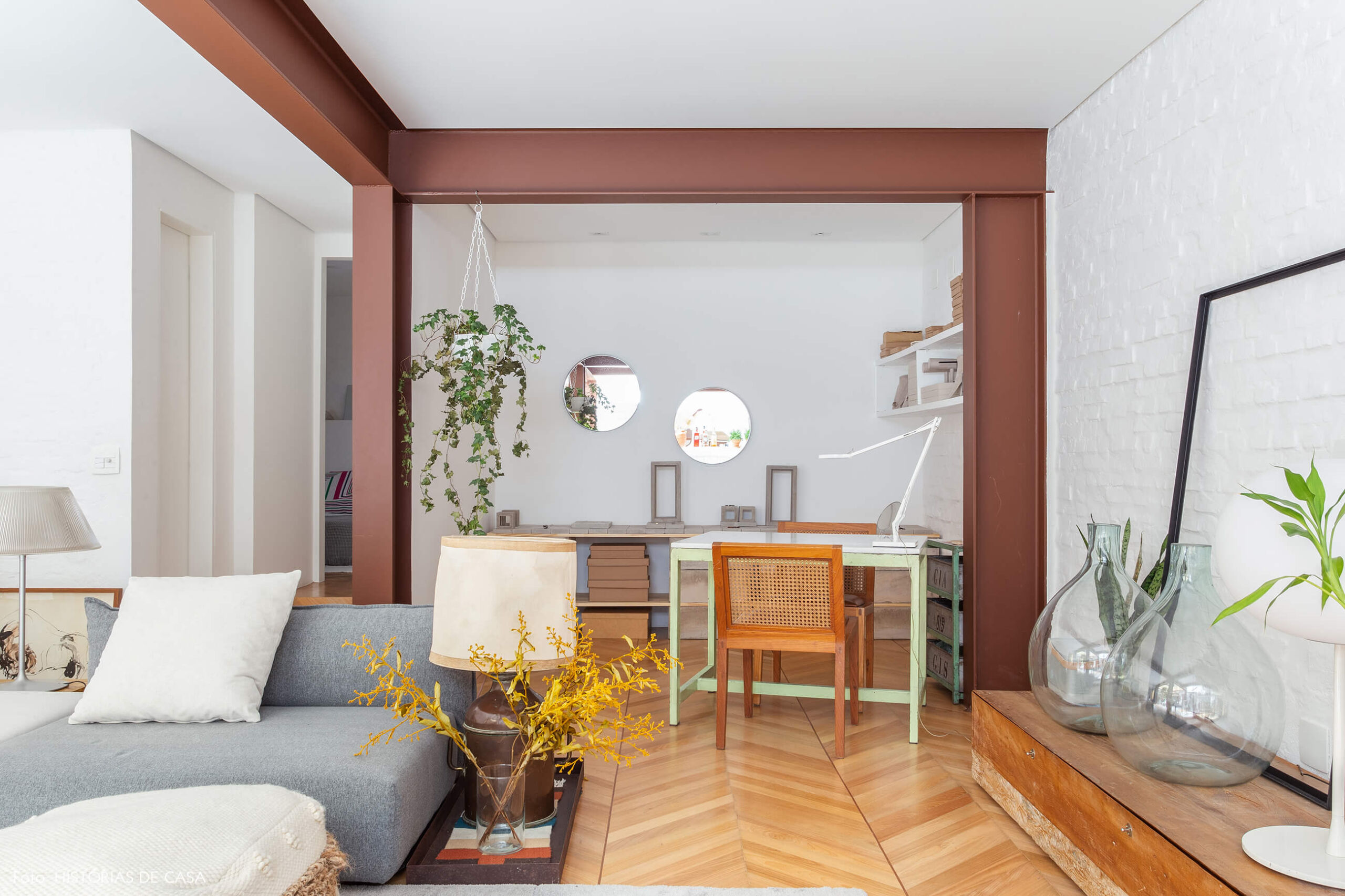 Sala integrada com home office e piso espinha de peixe