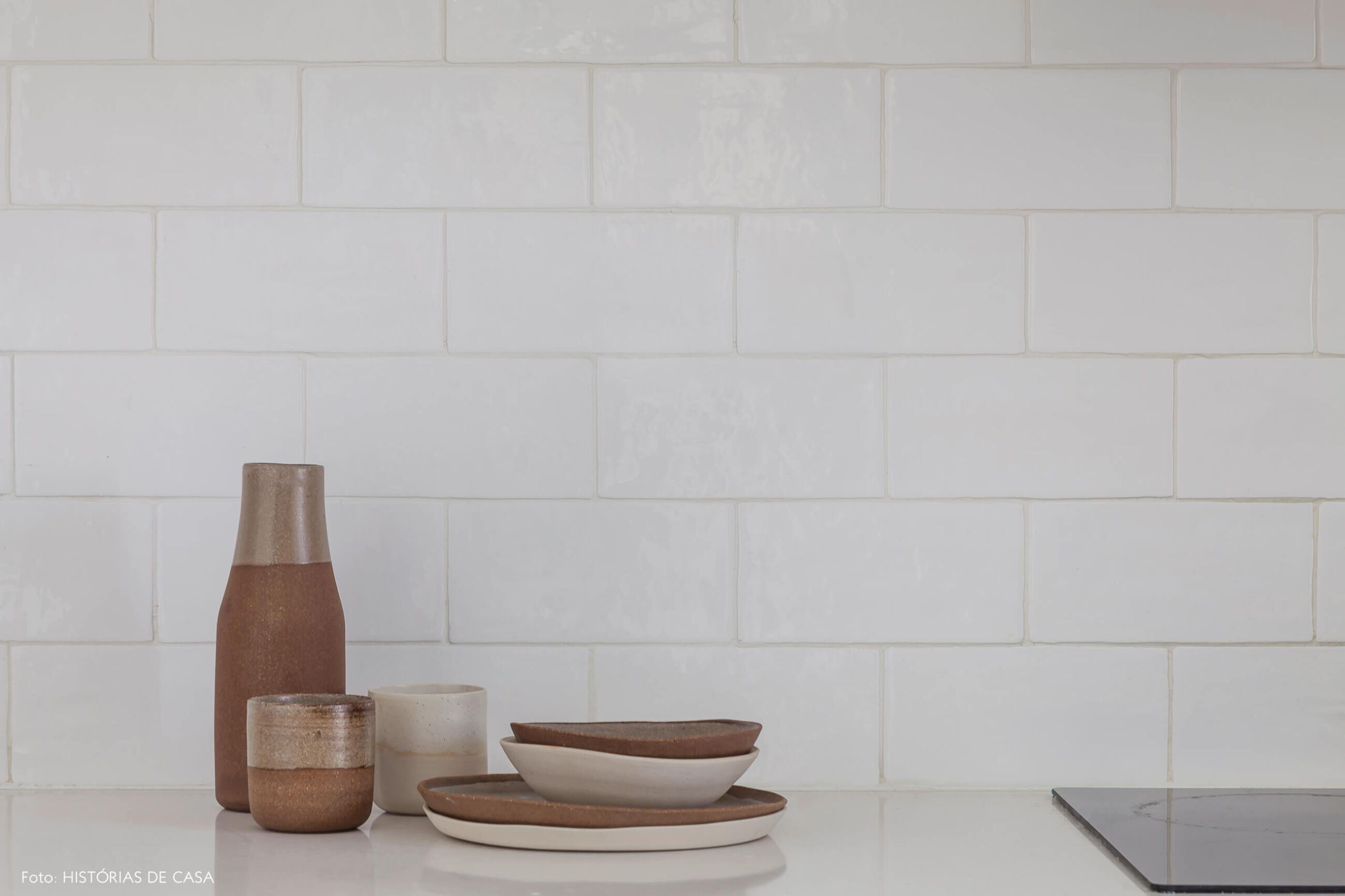 Parede com azulejos rústicos e peças de cerâmica