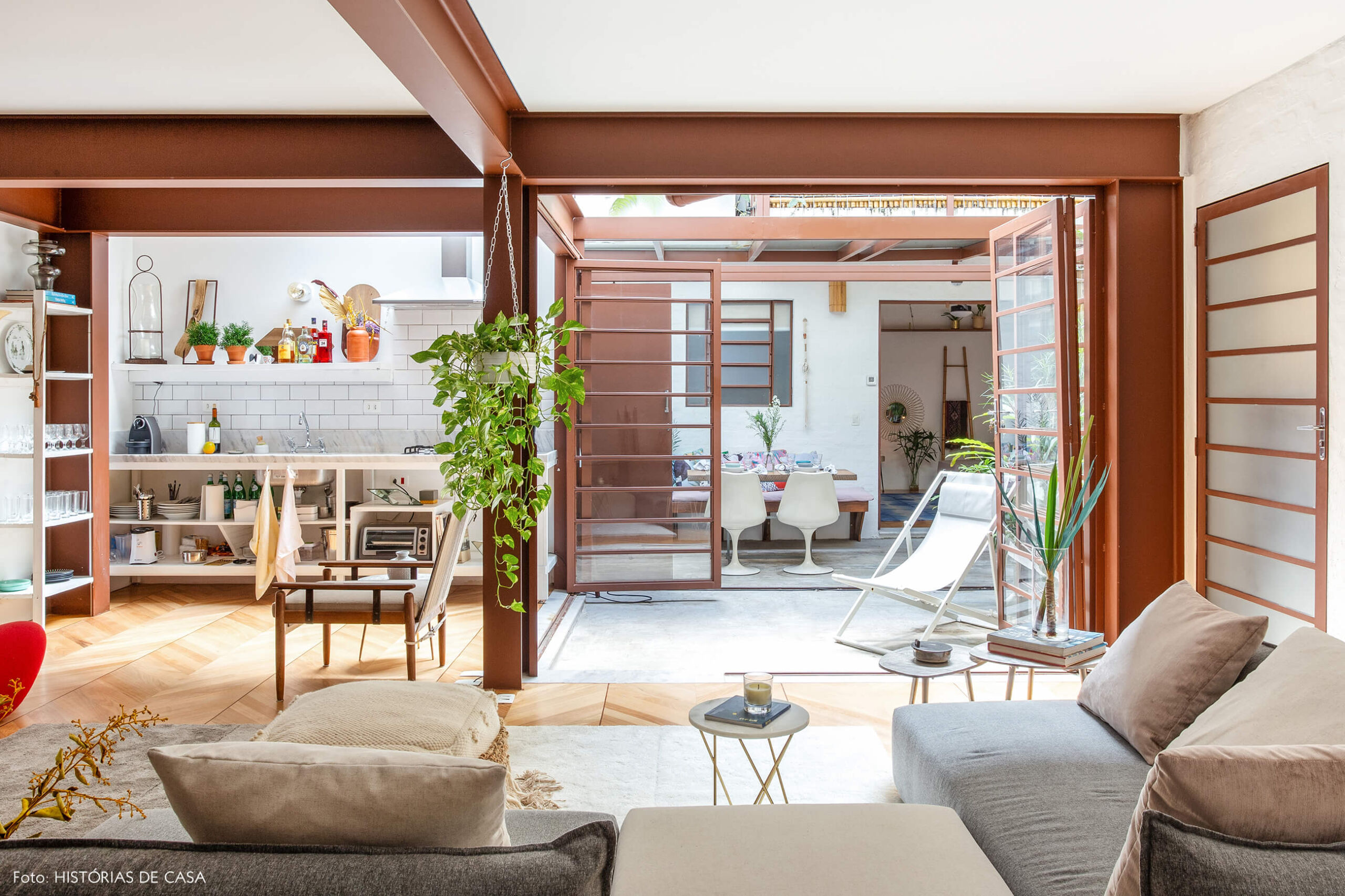 Sala integrada com vigas metálicas e jardim