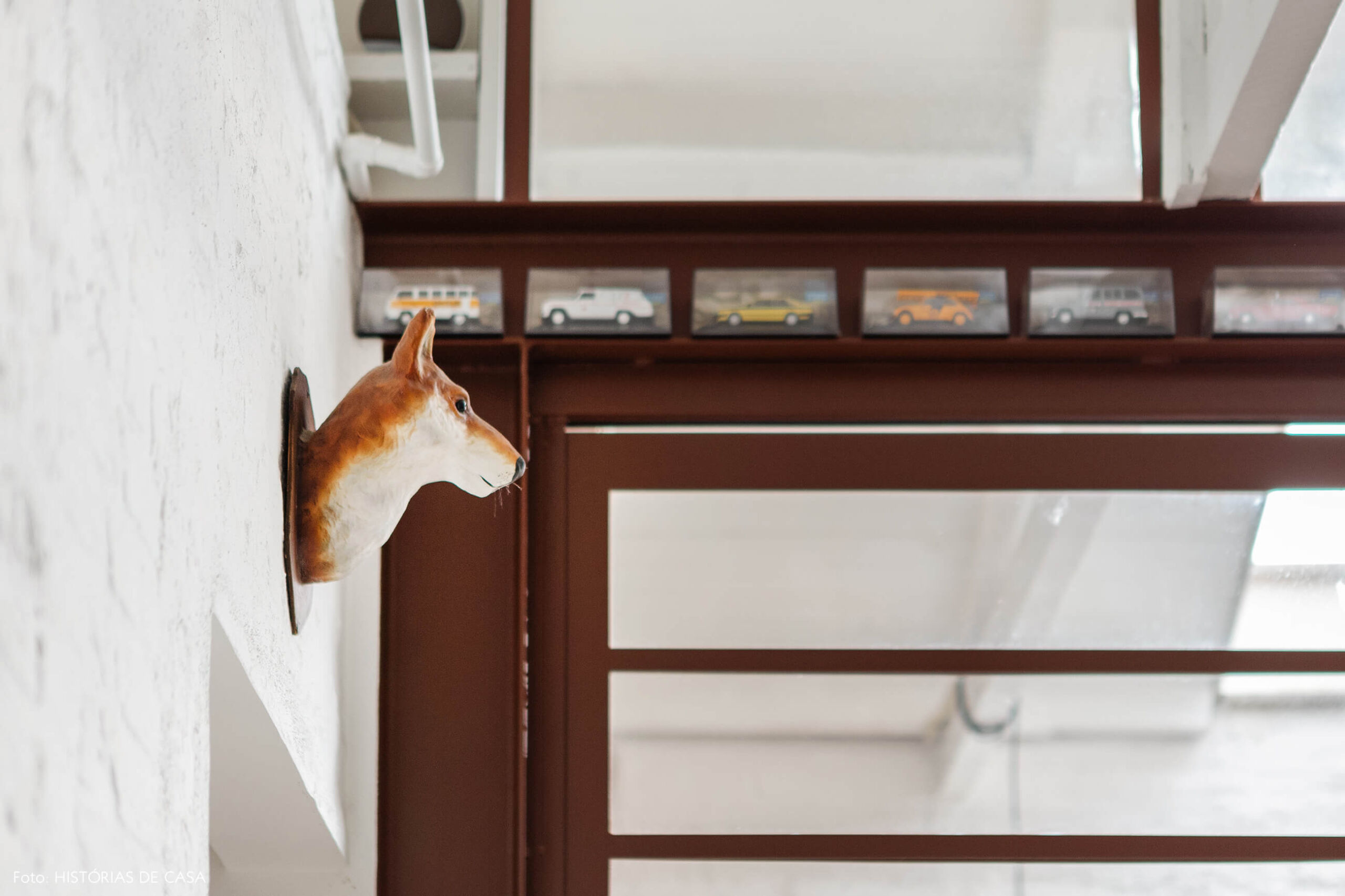 Sala com parede de tijolinho branco e portas de serralheria