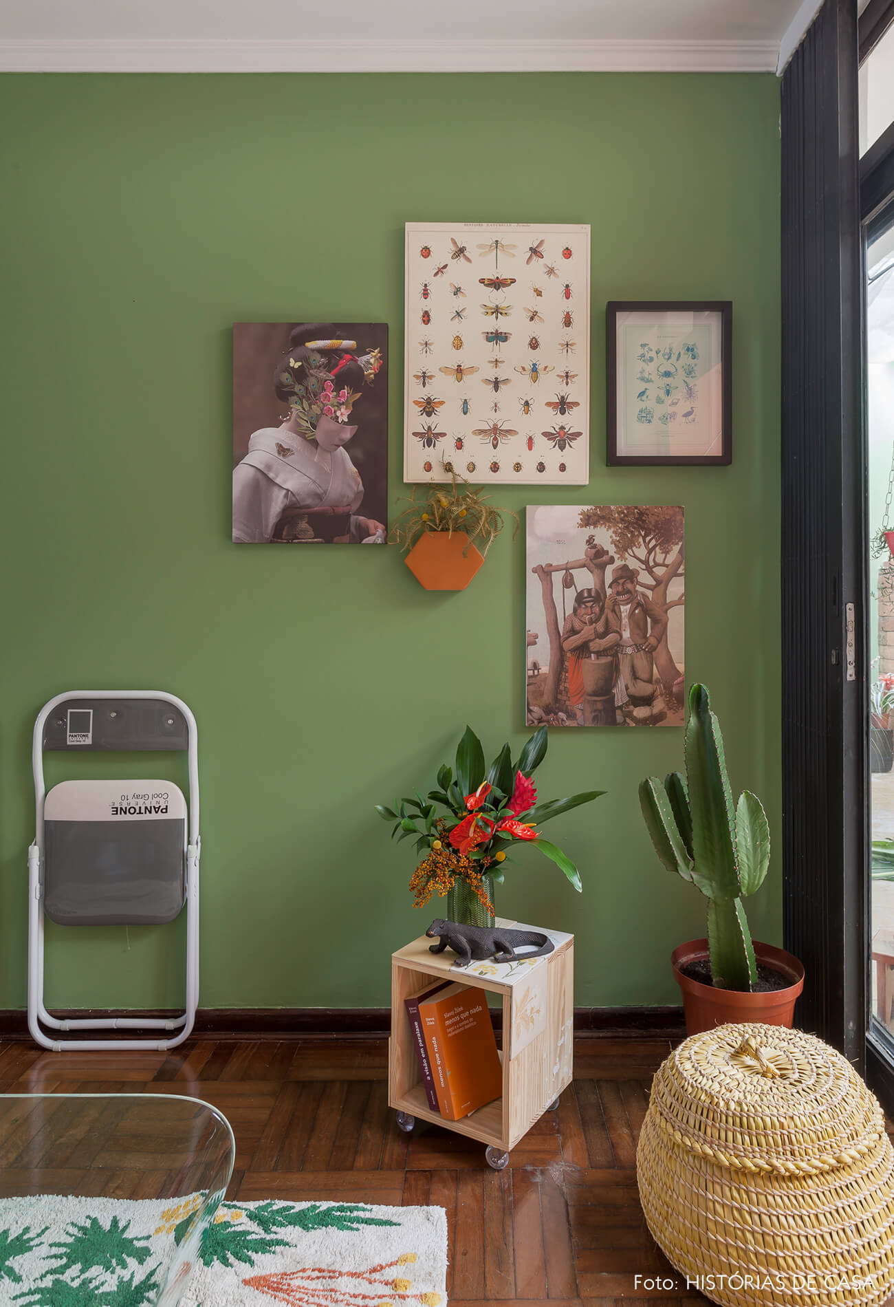 Sala com parede pintada de verde e quadros
