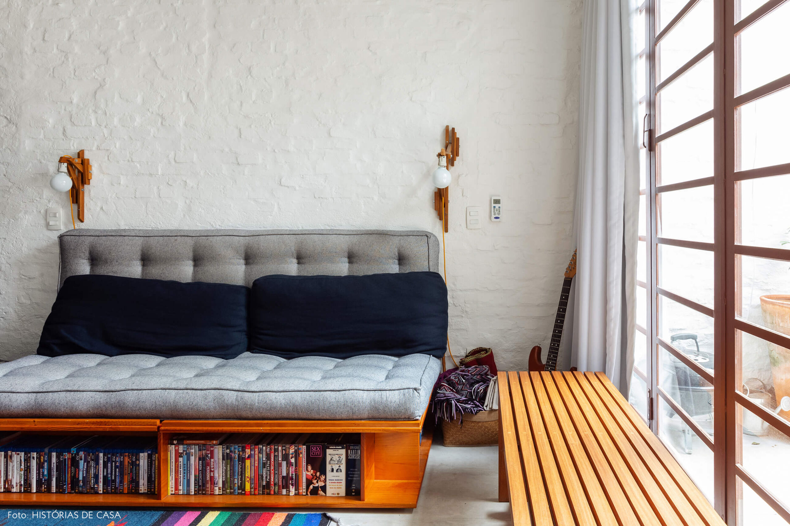 Quarto com sofá de futon e banco de madeira