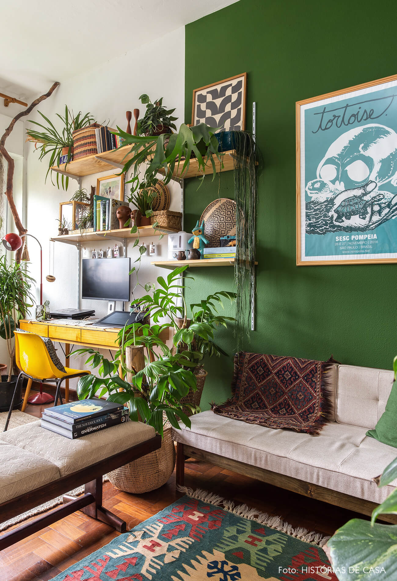 Home office com paredes pintadas de verde e móveis vintage