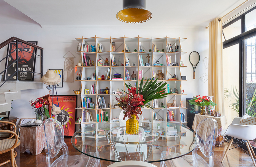 Sala com estante branca e mesa de vidro