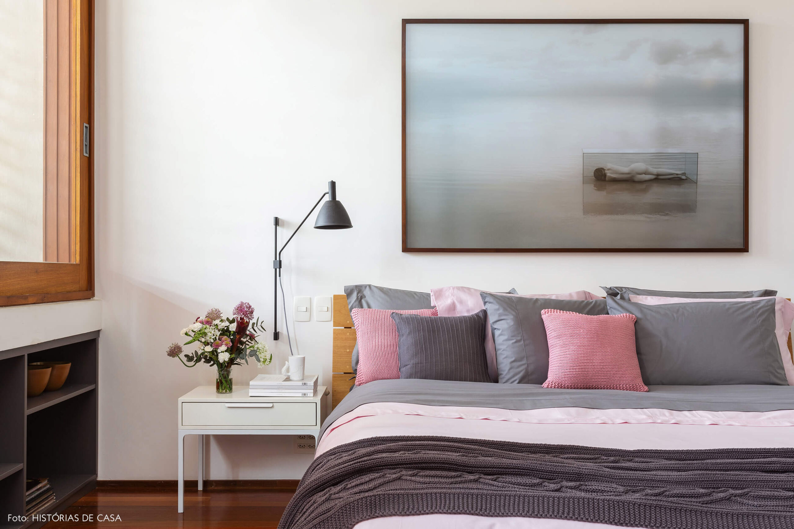 Quarto de casal com roupa de cama cinza e rosa