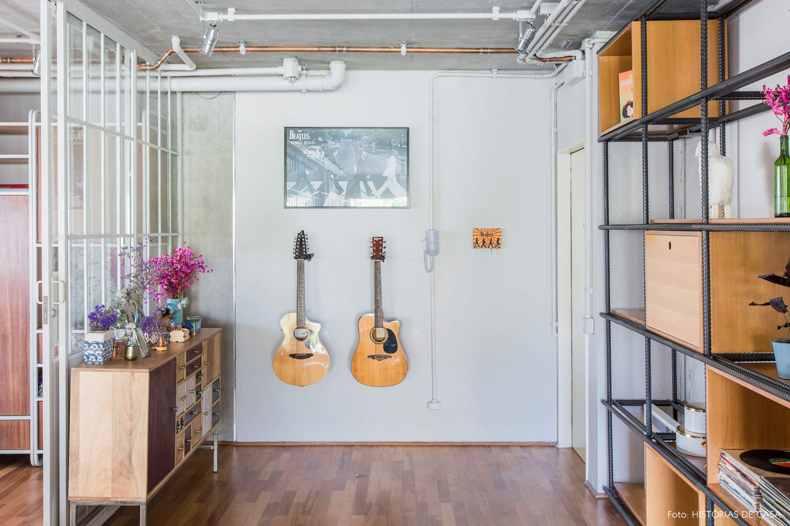 Hall de entrada com violão e tubulação aparente