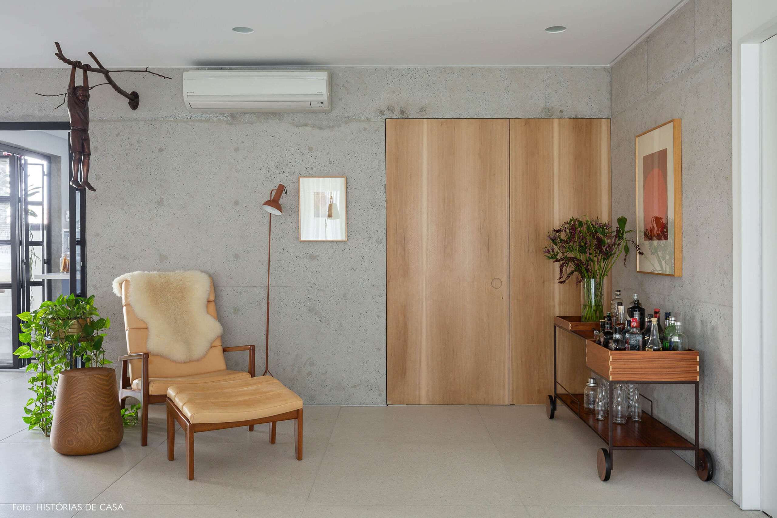 Sala com parede de concreto e painel de madeira