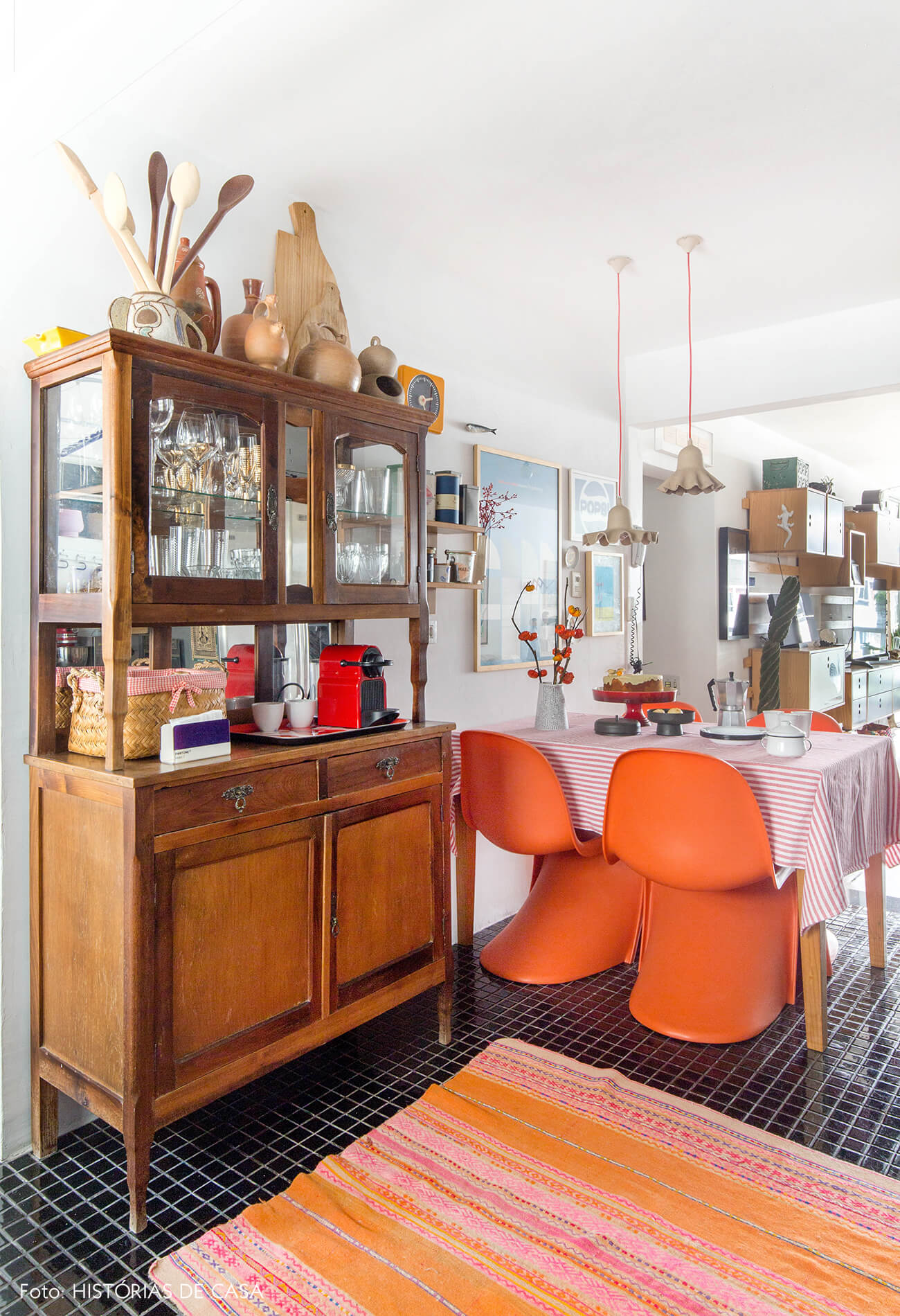 Cozinha com piso preto e cadeiras Panton laranja