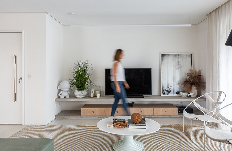 Sala em tons neutros, branco e prateleira de concreto