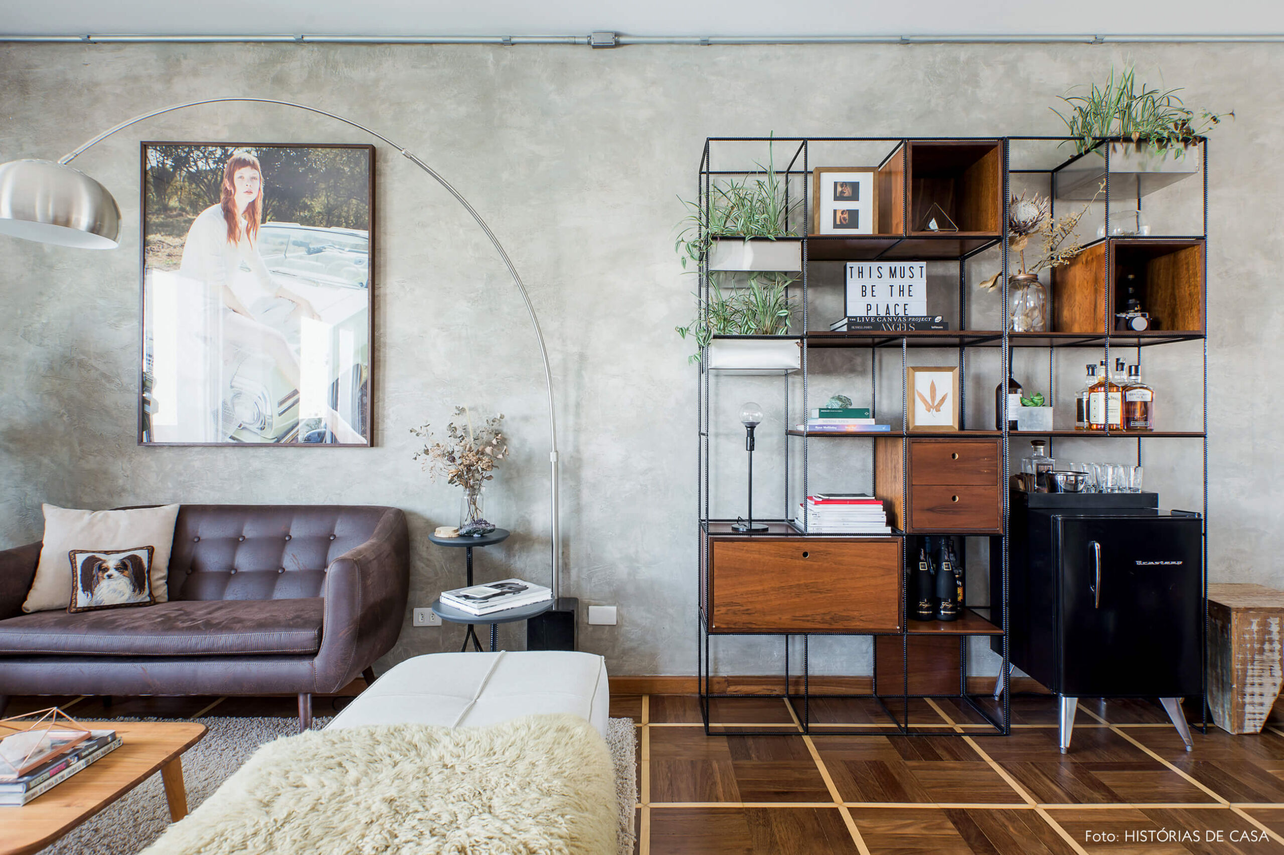 Sala com parede de cimento queimado e piso de parquet