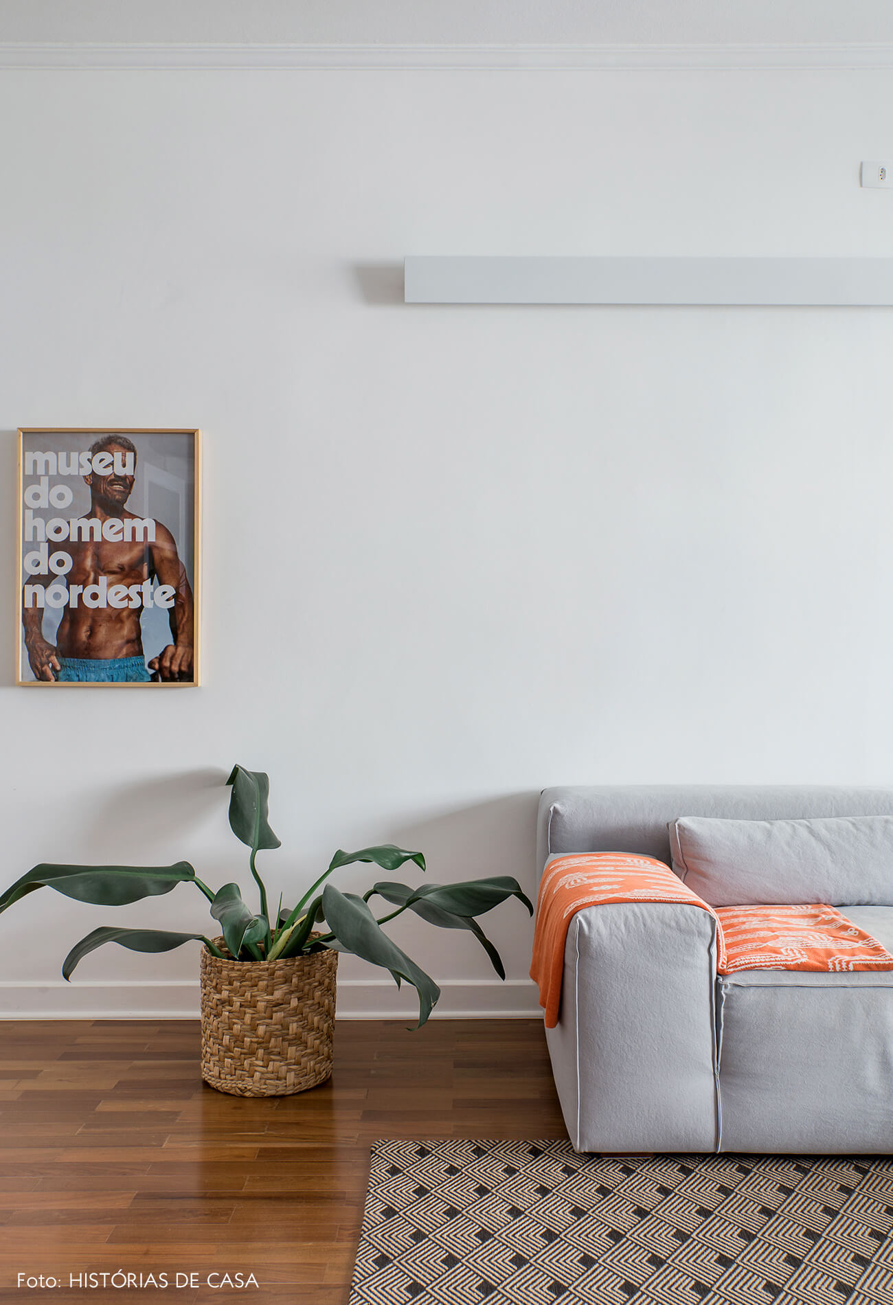 Sala integrada com piso de madeira e sofá cinza