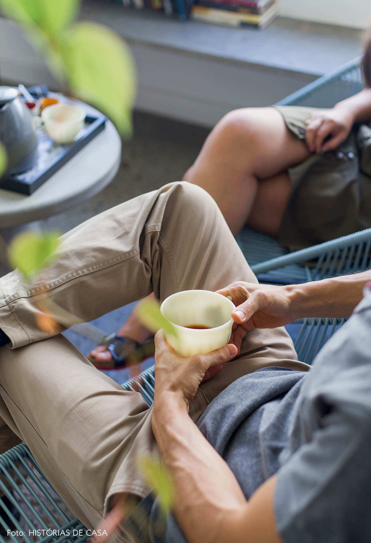 Sala com varanda integrada, piso de seixos e prateleiras de concreto com plantas