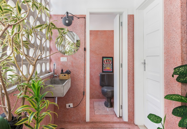 Banheiro com piso e paredes de granilite rosa