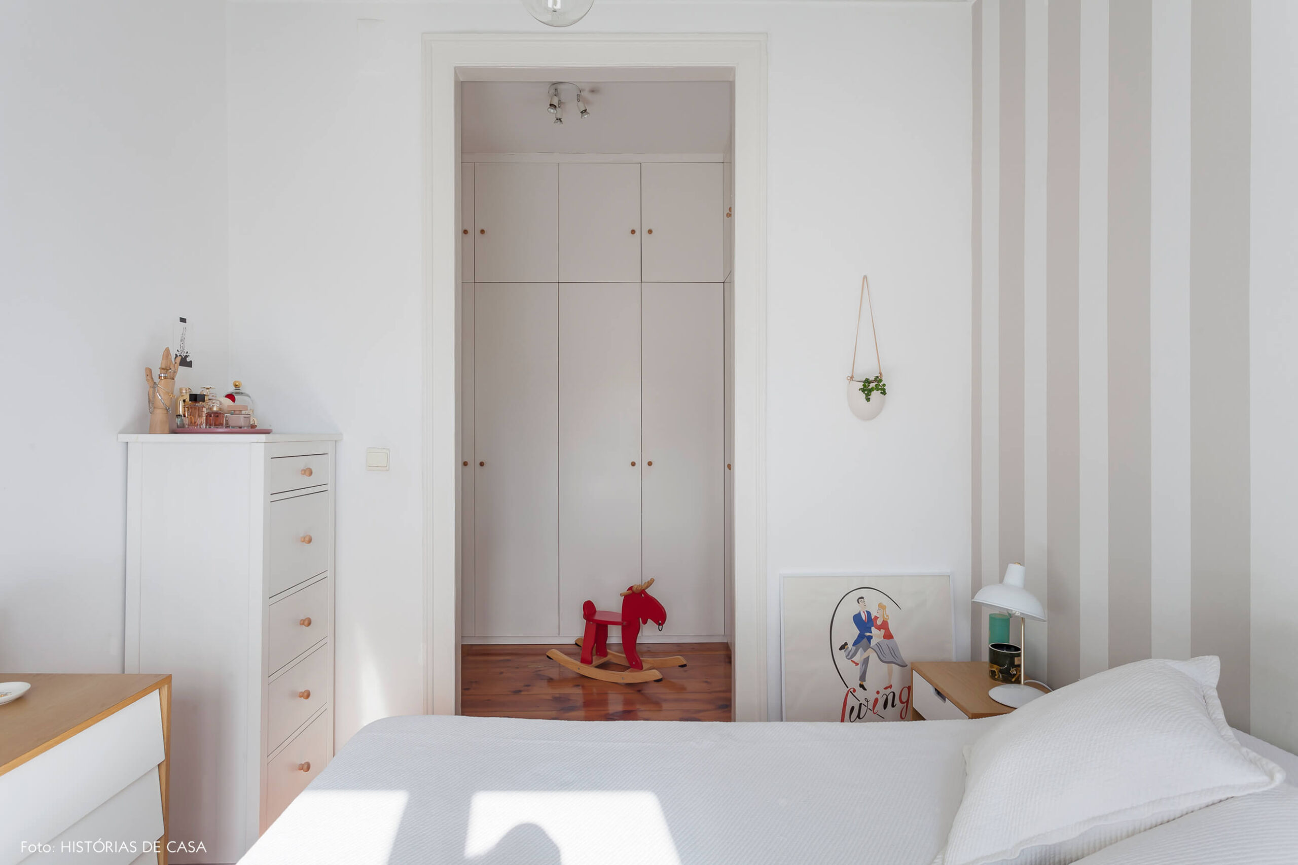 Quarto com papel de parede listrado cinza e closet