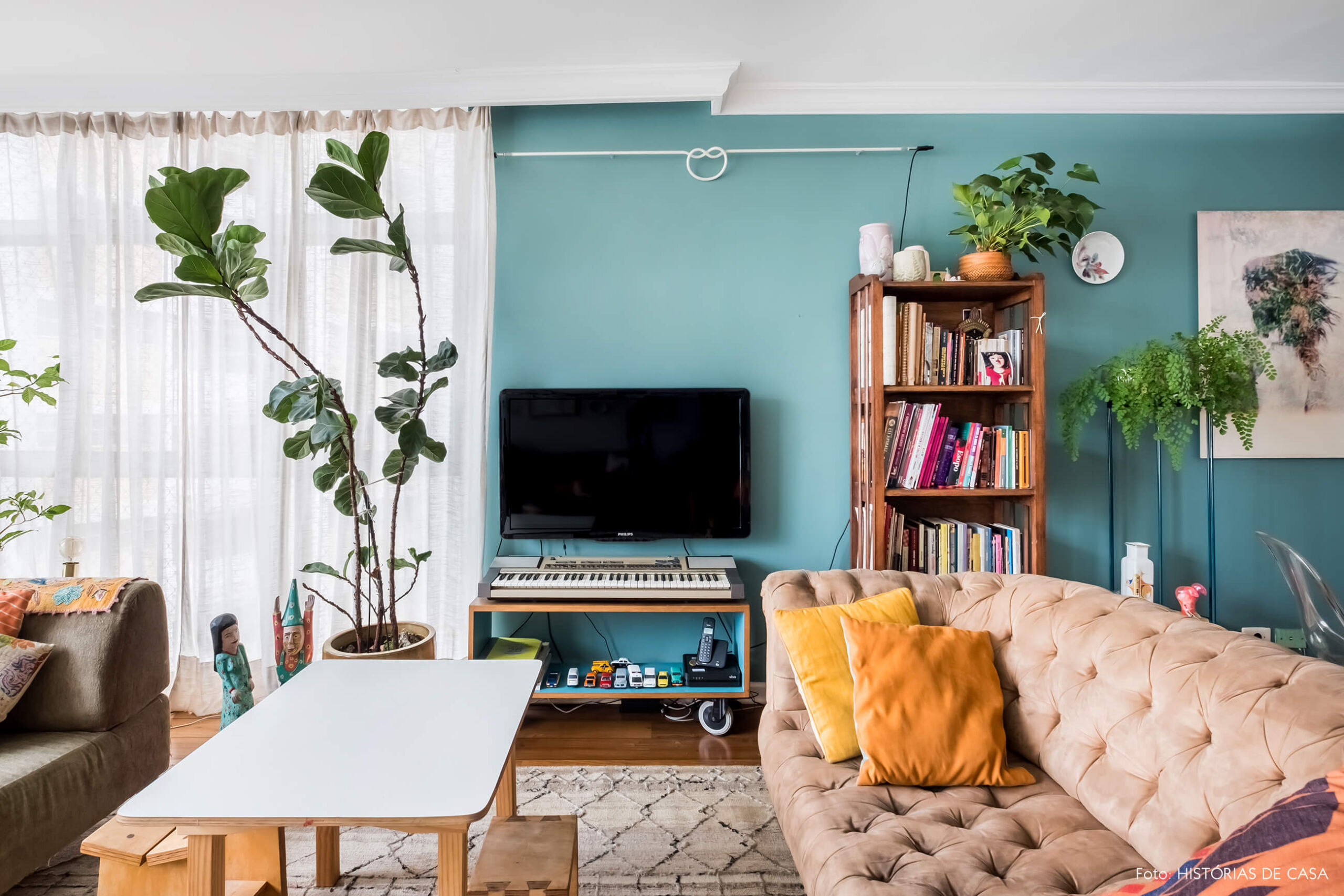 Sala com móveis garimpados e parede pintada de azul esverdeado