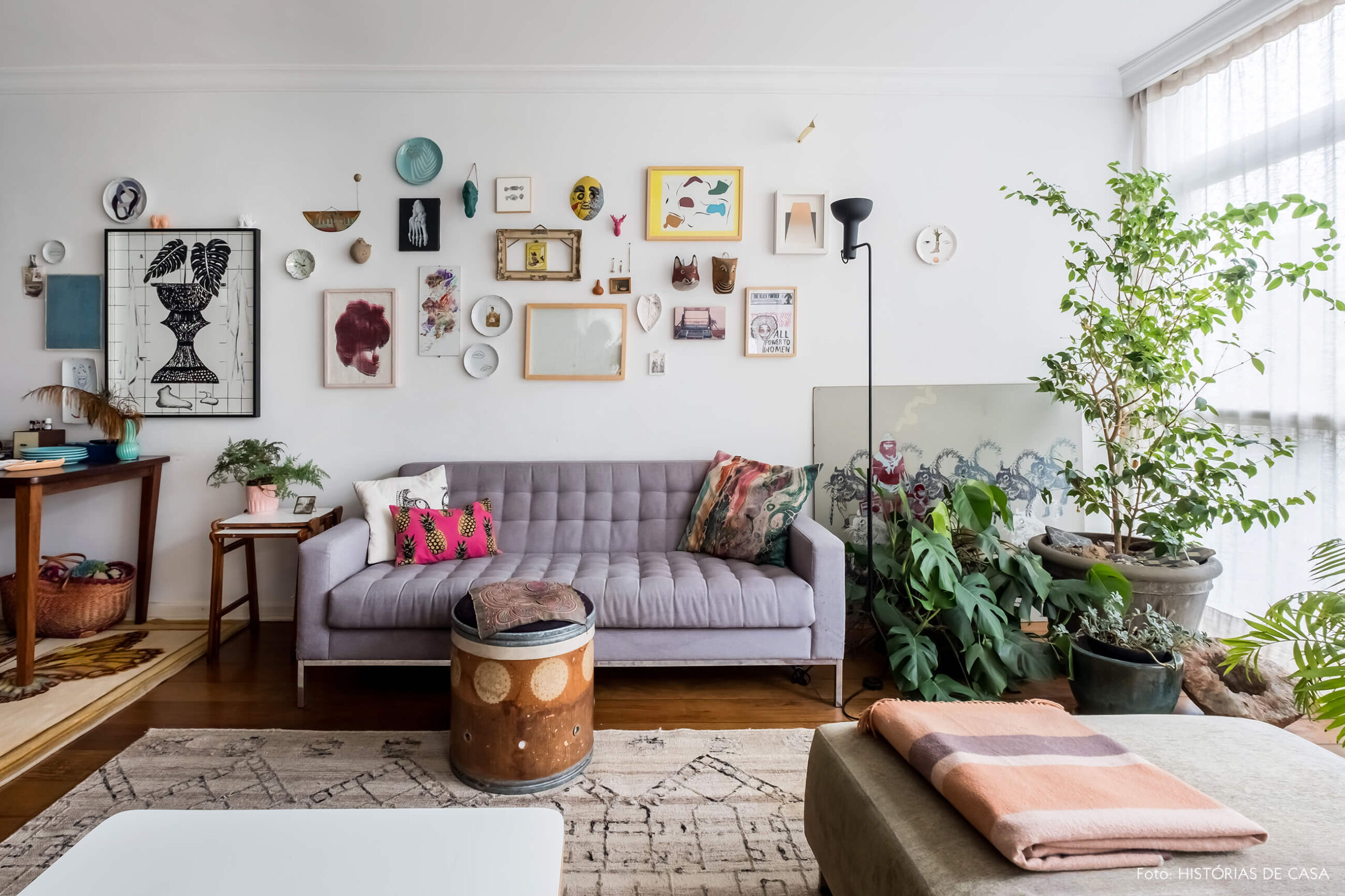 Apartamento integrado, sala com sofá cinza e plantas