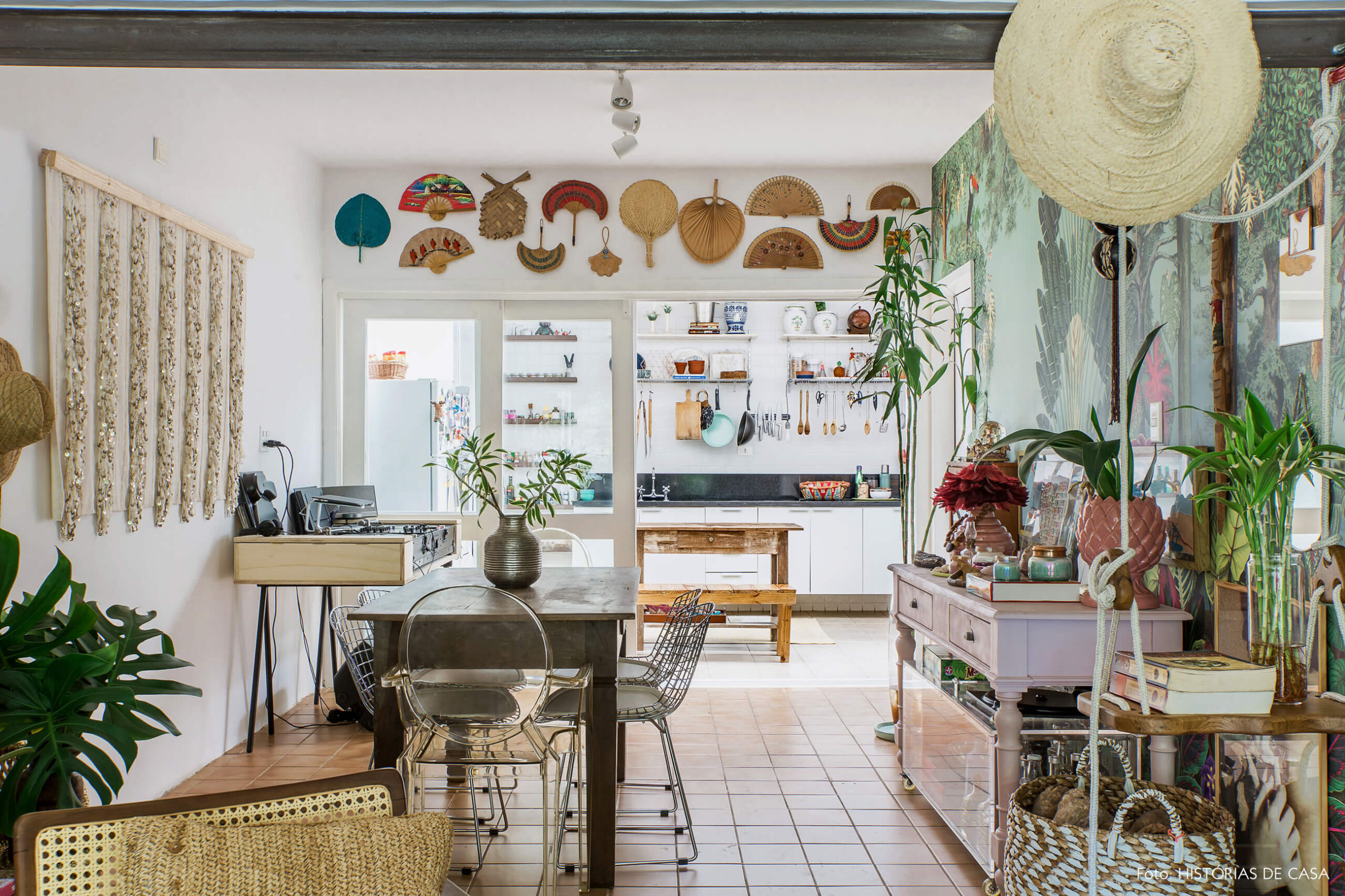Casa com decoração eclética, sala de jantar com portas de correr de vidro para a cozinha