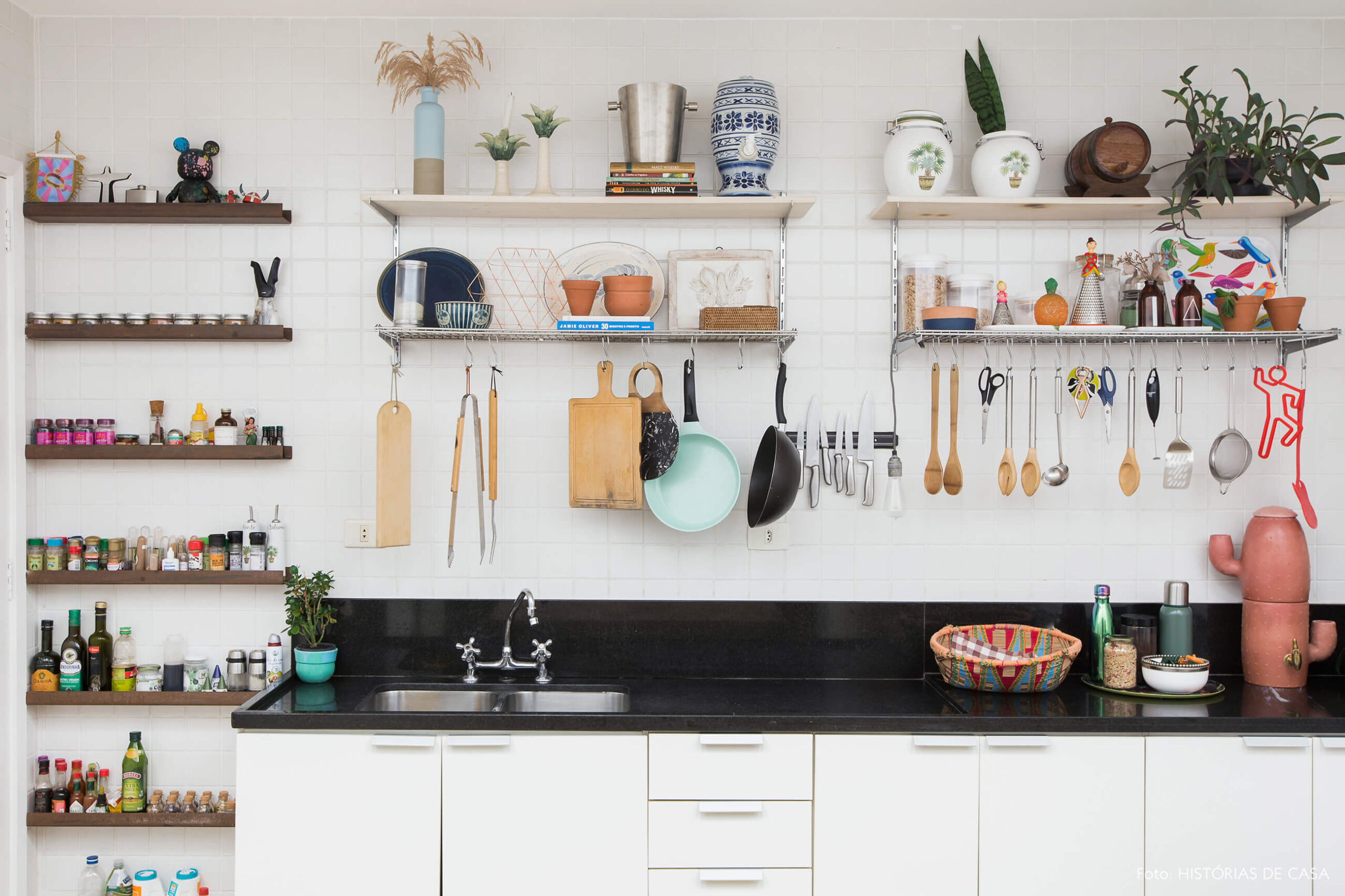 Cozinha com azulejos simples e prateleiras aramadas sobre a pia