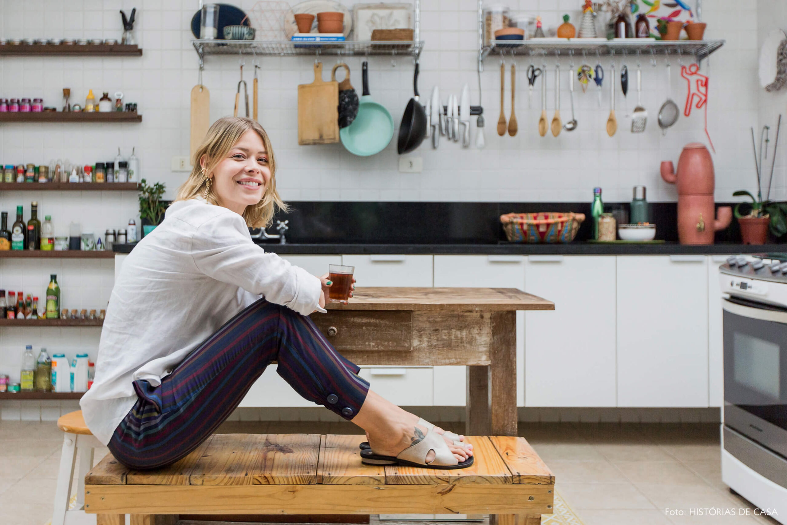 Cozinha com móveis simples, mesa e banco de madeira de demolição