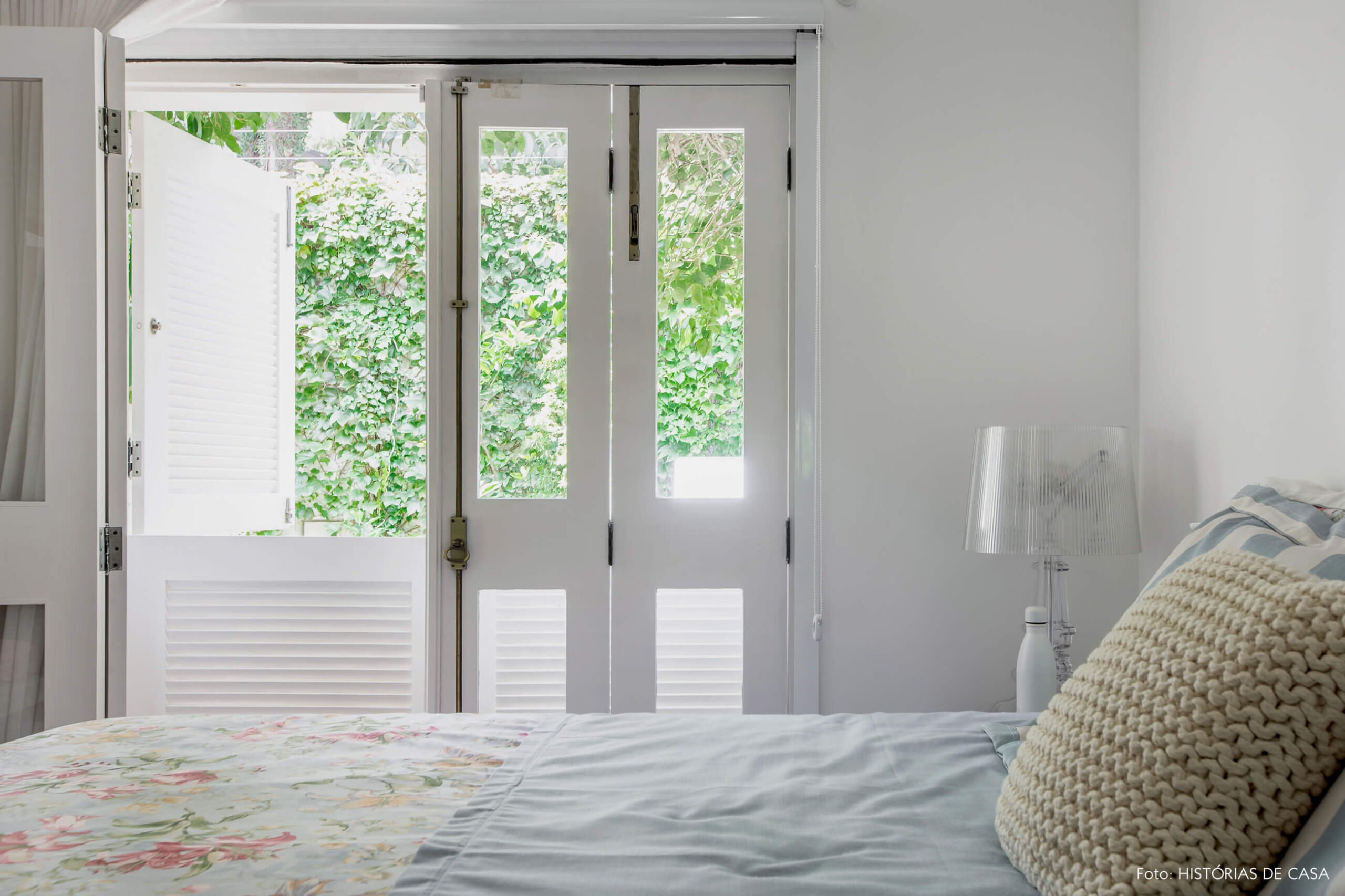 Quarto branco com vista para o jardim