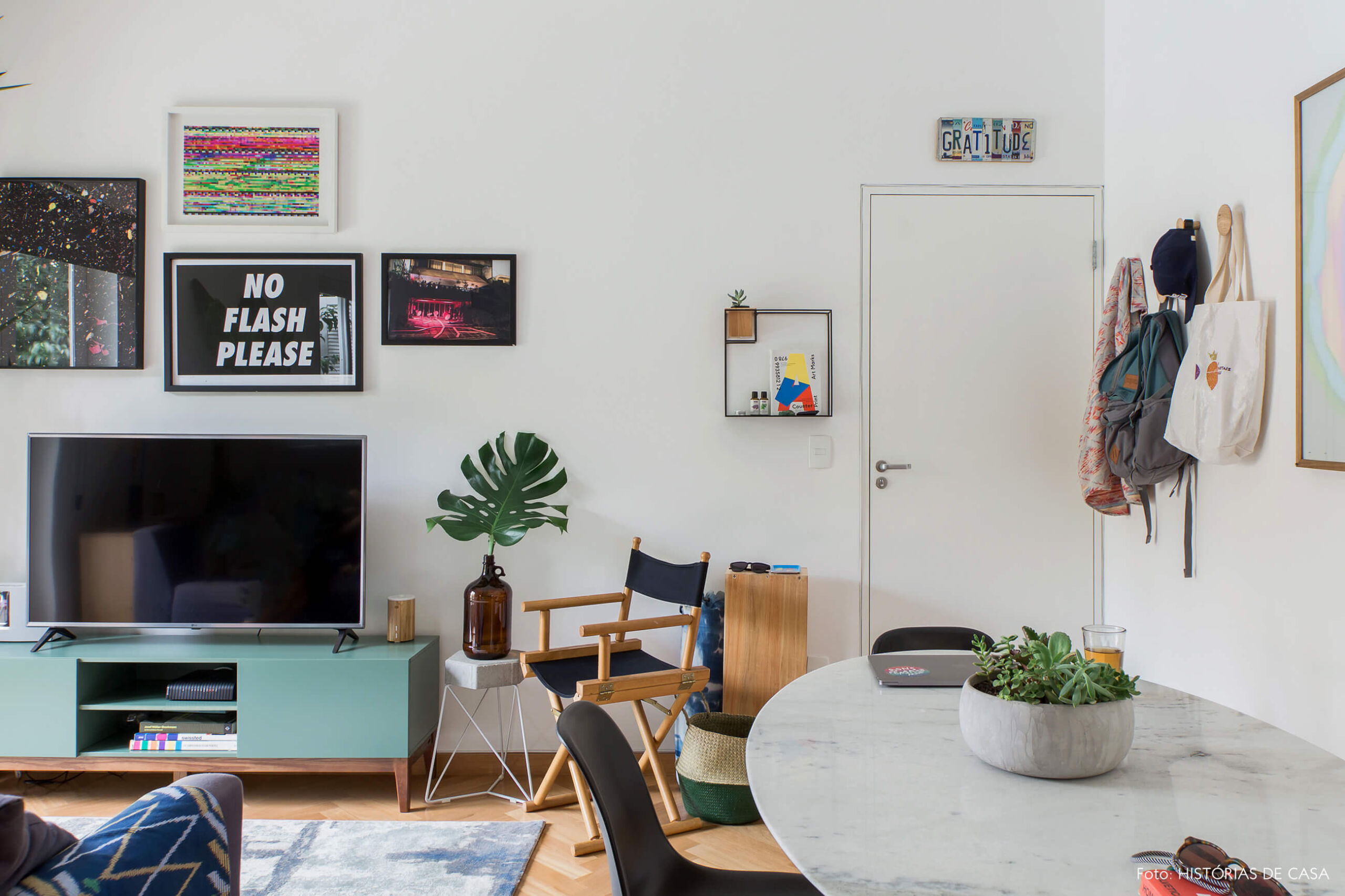 Apartamento alugado com decoração inspiradora, parede de quadros atrás da televisão