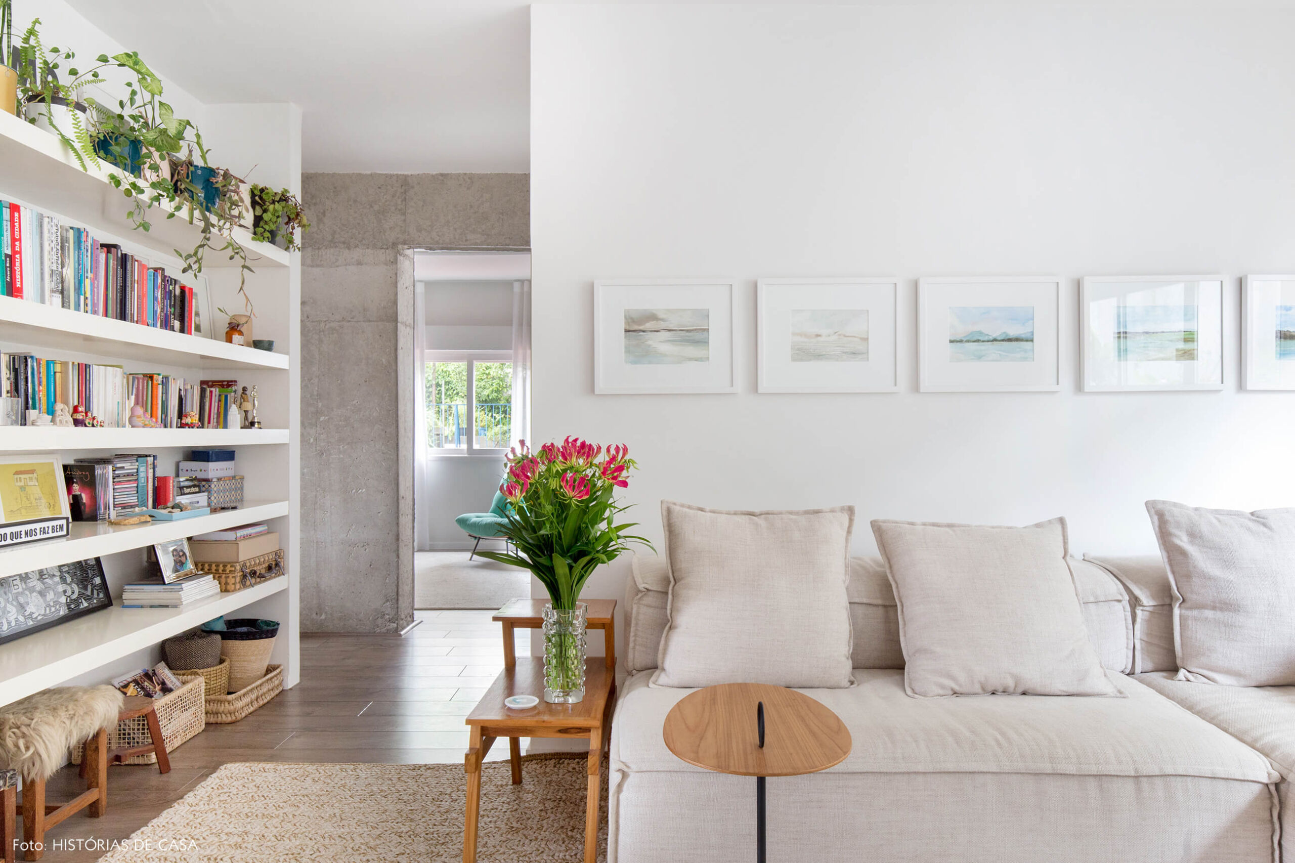 Sala em tons neutros com quadros de aquarelas na parede