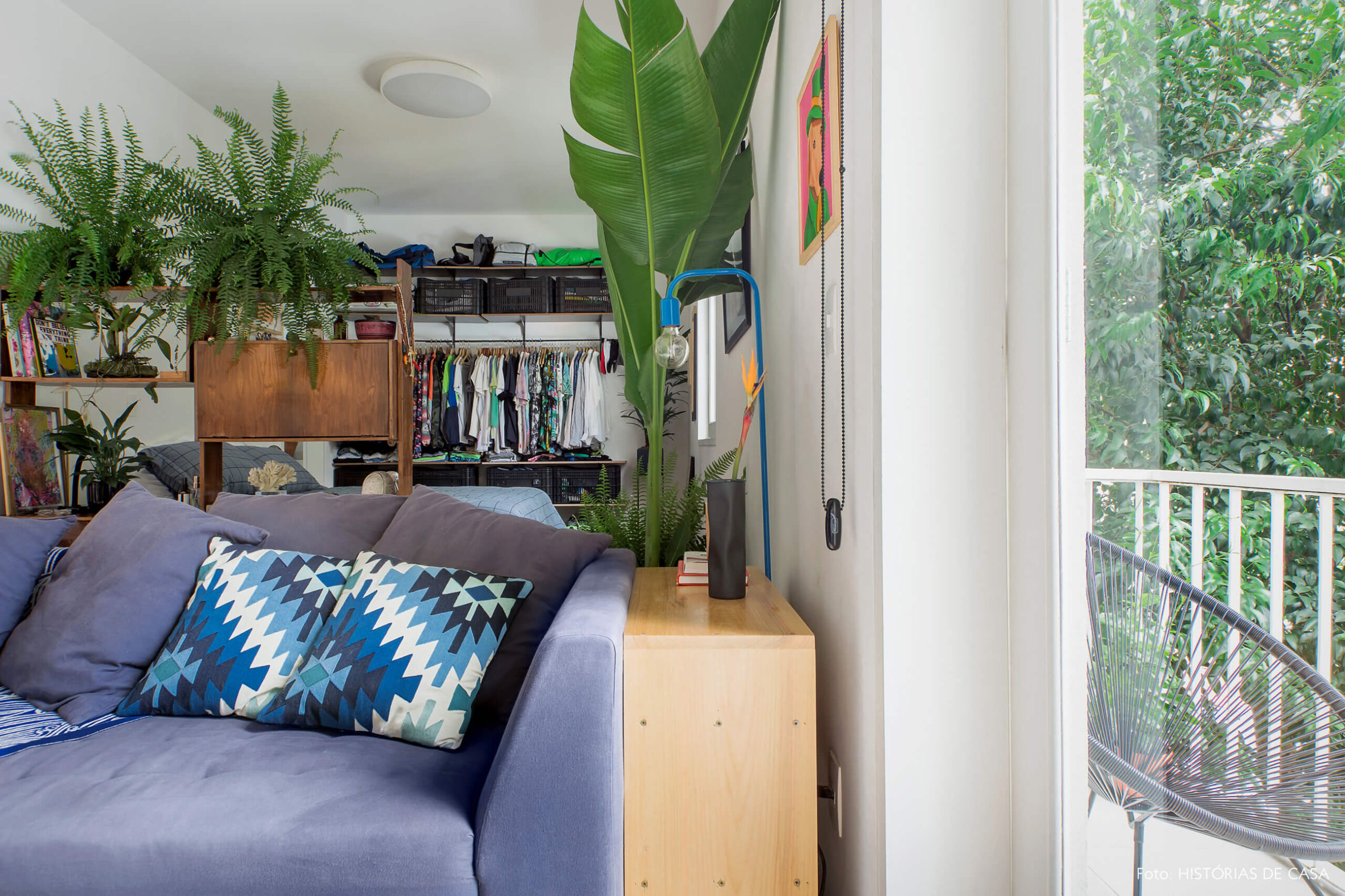 Sala integrada ao quarto com pequena varanda e muitas plantas
