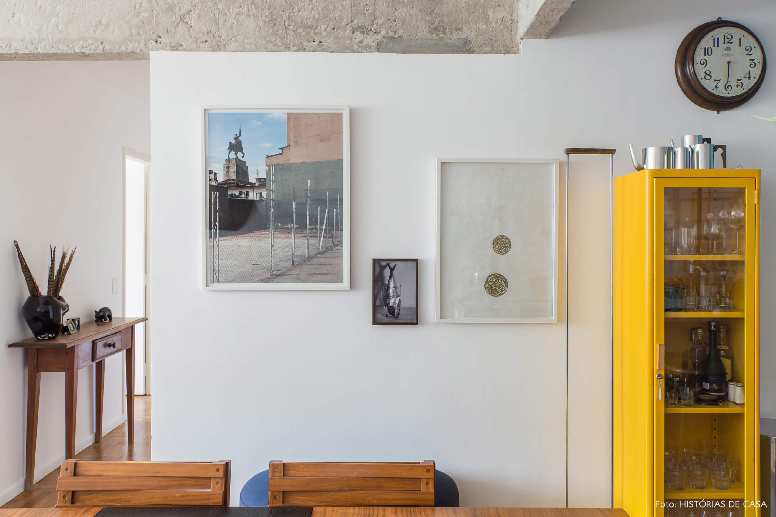 Parede de quadros e armário antigo amarelo