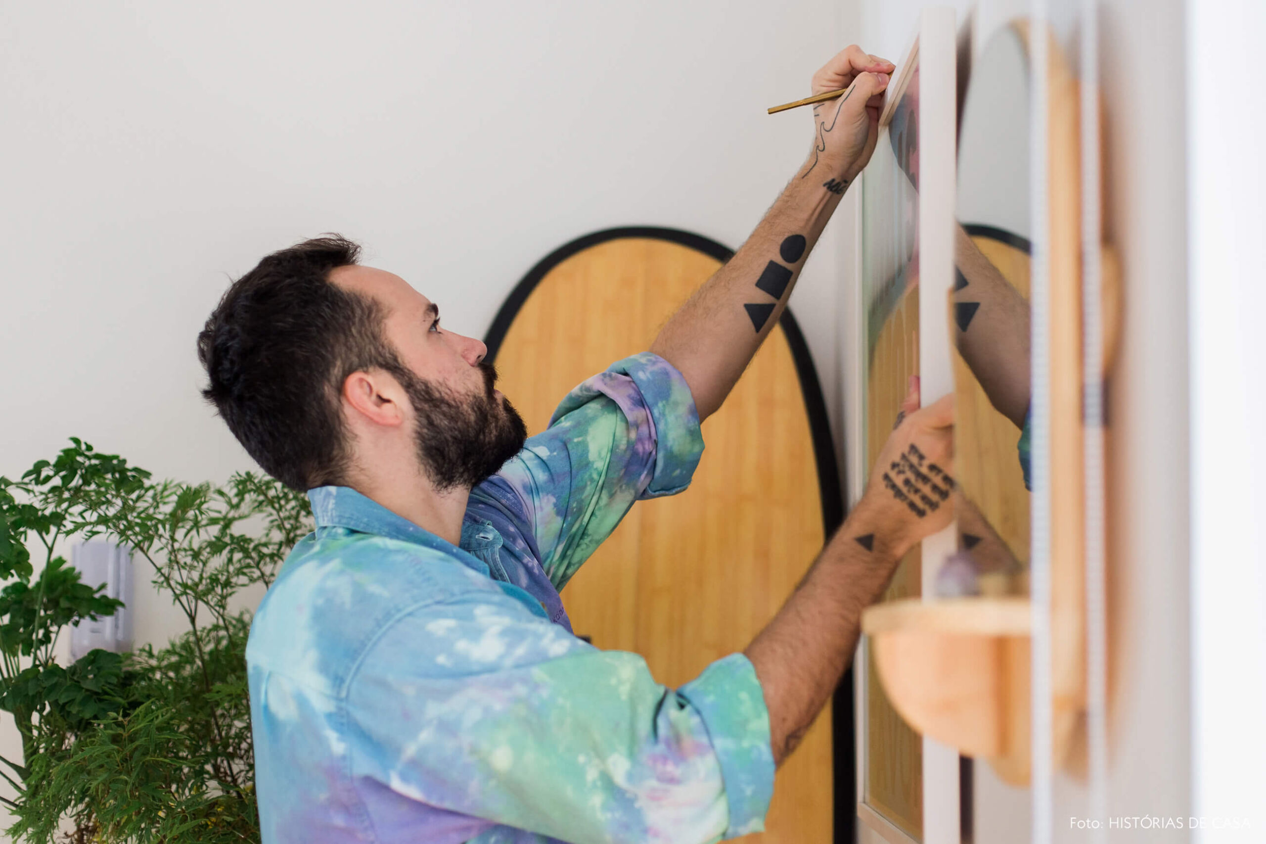 Felipe pendurando quadros na parede